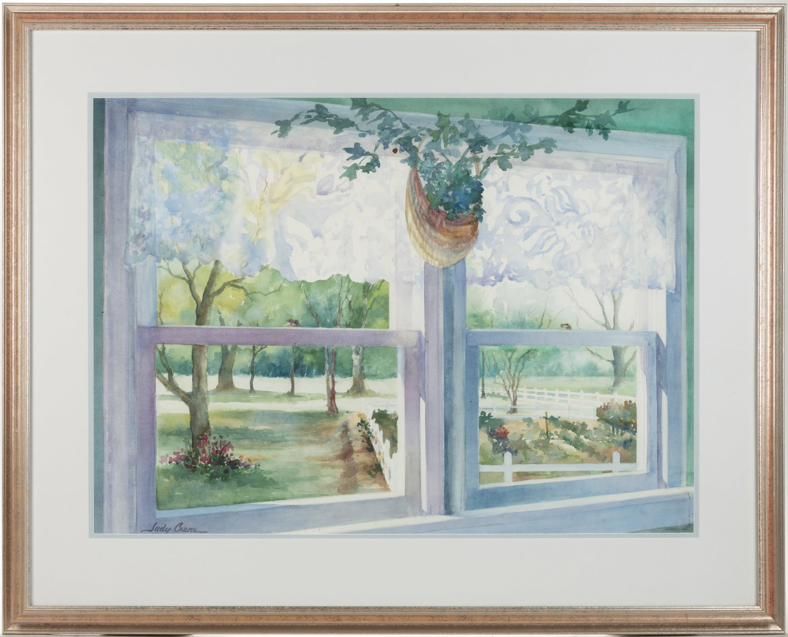 JUDY CRANE (NORTH CAROLINA, ACTIVE 20TH/21ST CENTURY) LANDSCAPE FROM A WINDOW PAINTING: JUDY CRANE (NORTH CAROLINA, ACTIVE 20TH/21ST CENTURY) LANDSCAPE FROM A WINDOW PAINTING, watercolor on paper, depicting a two-part window with a wall basket hanging from the central post looking out on