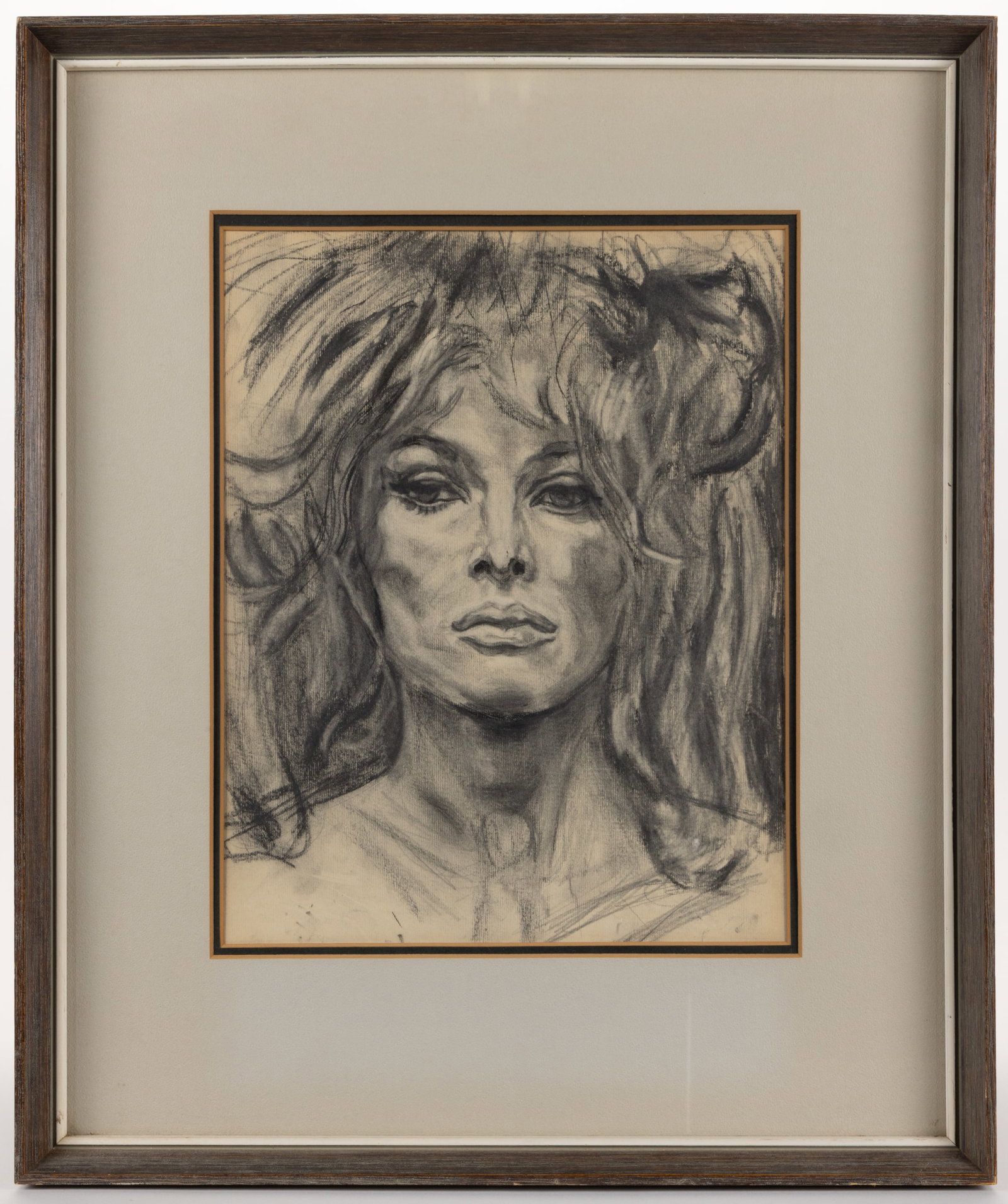 AMERICAN SCHOOL (20TH CENTURY) PORTRAIT OF A LADY: AMERICAN SCHOOL (20TH CENTURY) PORTRAIT OF A LADY, charcoal on paper, depicting a sultry female face with voluptuous flowing hair. Possibly illegible signature lower right. Housed under glass in a