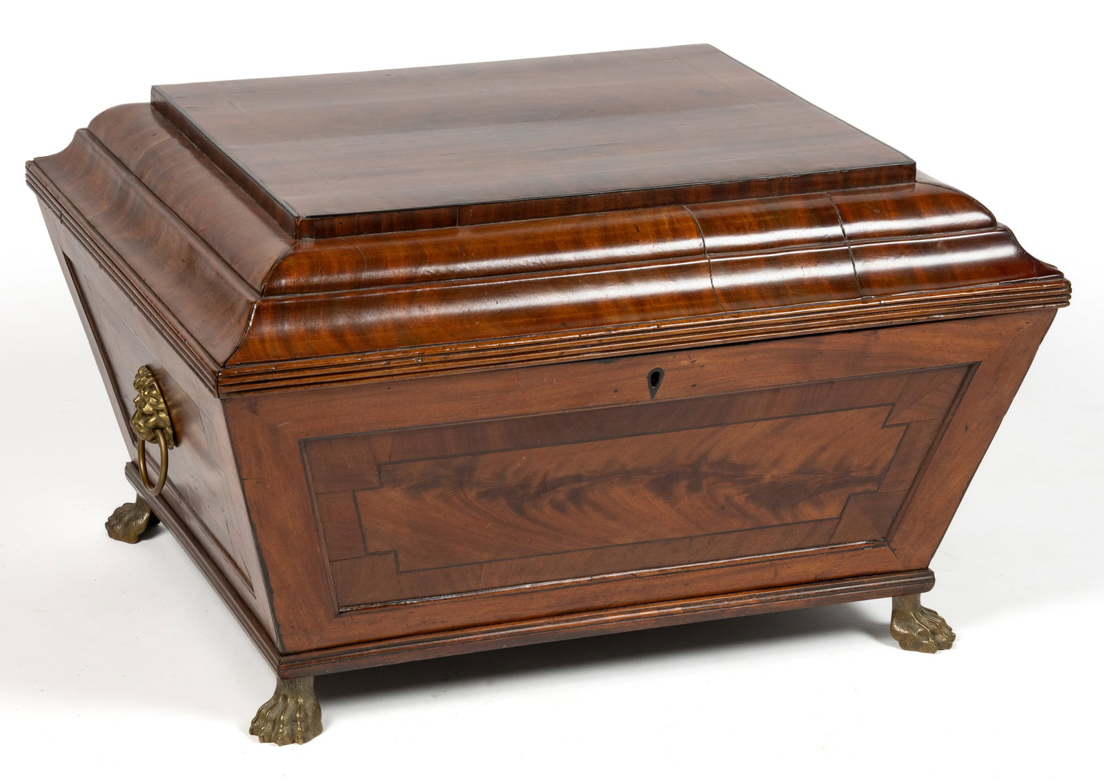 ENGLISH REGENCY BRASS-INLAID MAHOGANY CELLARETTE / BOTTLE CASE: ENGLISH REGENCY BRASS-INLAID MAHOGANY CELLARETTE / BOTTLE CASE, sarcophagus form with step-molded lid having reeded edge, brass lion mask handles, and cast-brass paw feet. Pine secondary wood. Retaini