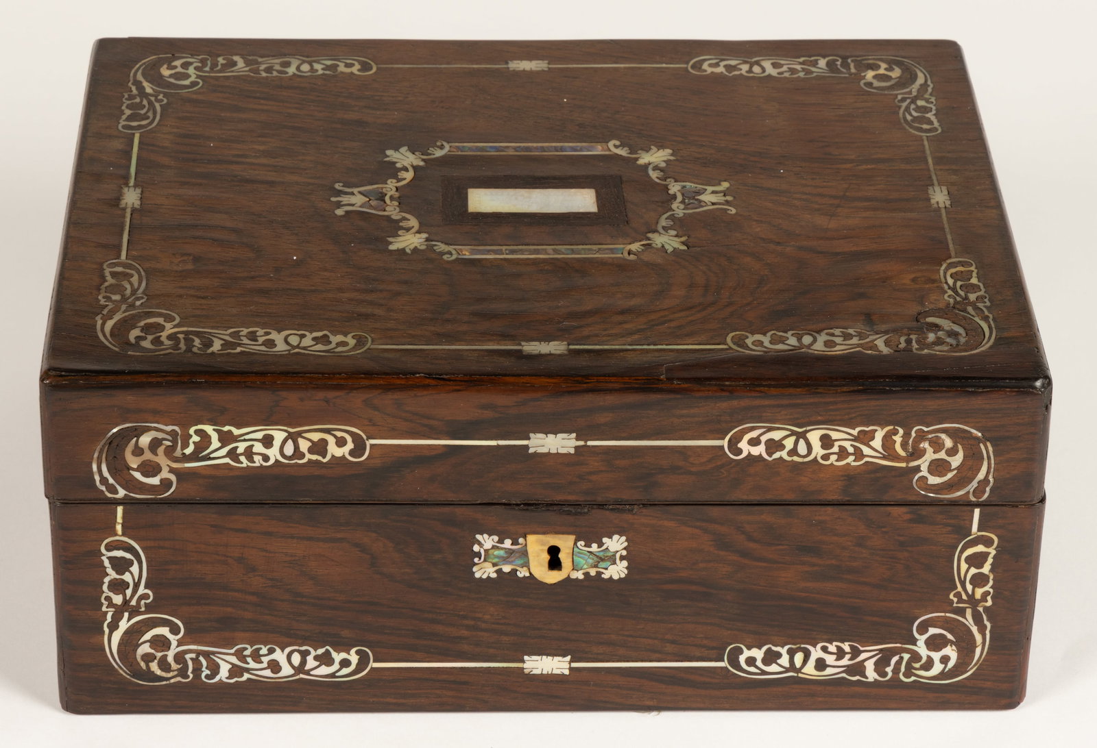 BRITISH ROSEWOOD WITH MOTHER-OF-PEARL INLAY SEWING WORK BOX: BRITISH ROSEWOOD WITH MOTHER-OF-PEARL INLAY SEWING WORK BOX, rectangular form with cover and front side each having a stylized scroll ornamentation mother-of-pearl decoration, centrally having a