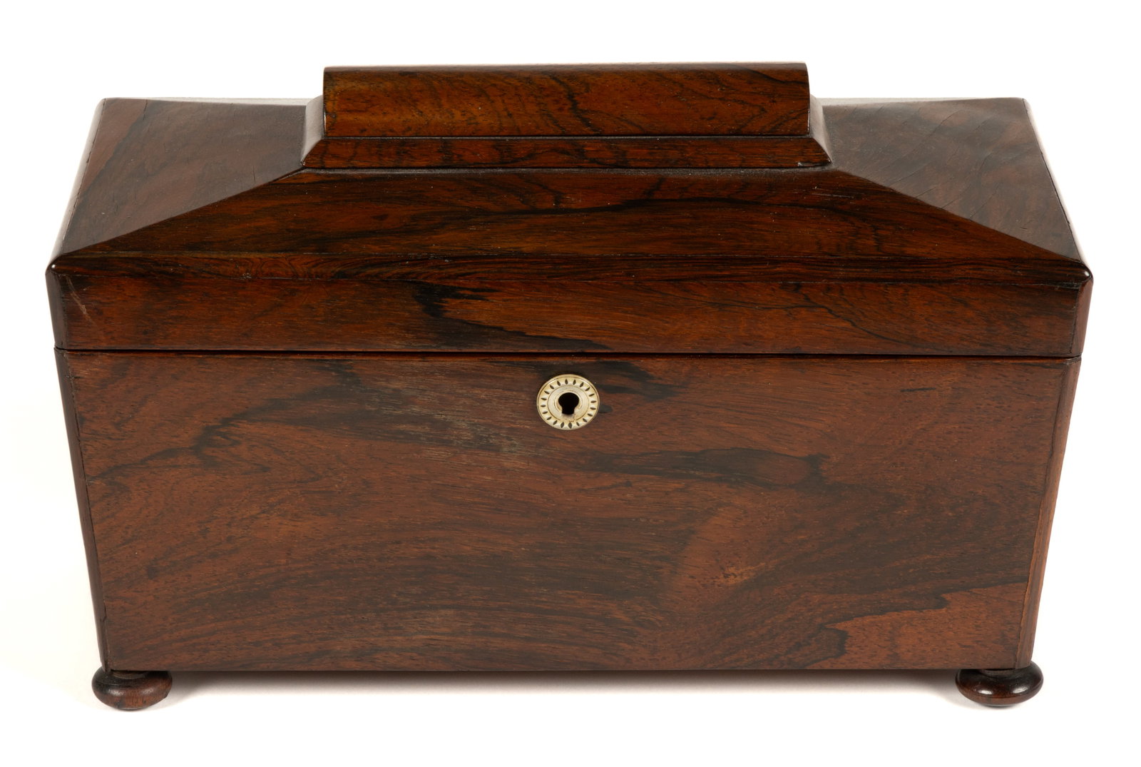 BRITISH ROSEWOOD SARCOPHAGUS-FORM TEA CADDIE: BRITISH ROSEWOOD SARCOPHAGUS-FORM TEA CADDIE, raised on four compressed button-form form feet, hinged lid opens to reveal a base which is fitted with a central compartment and having a color