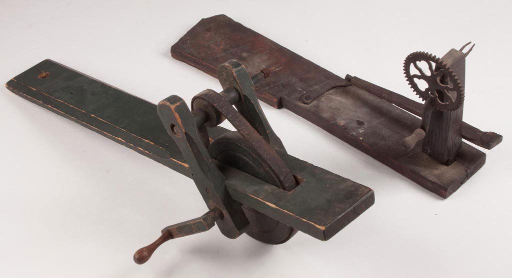 WOODEN MECHANICAL APPLE PEELERS, LOT OF TWO: WOODEN MECHANICAL APPLE PEELERS, LOT OF TWO, comprising of a bench mounted example with green paint and wooden pin construction; and a table top example, with later cast-iron wheel, together by associ