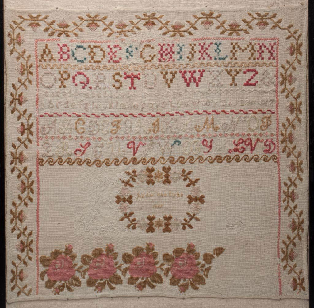 LYDIA VAN DYKE, 1847 NEEDLEWORK SAMPLER: LYDIA VAN DYKE, 1847 NEEDLEWORK SAMPLER, silk on linen, five lines of letters and numbers above a wreath containing "Lydia Van Dyke / 1847", and four large roses, three sides framed by a floral vine b