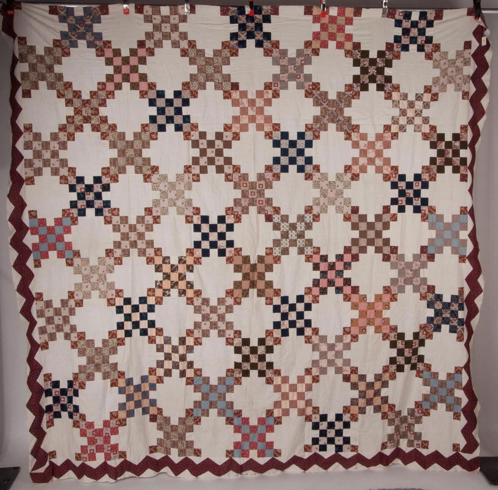 MID-ATLANTIC PIECED DOUBLE IRISH CHAIN QUILT TOP: MID-ATLANTIC PIECED DOUBLE IRISH CHAIN QUILT TOP, eighty 9 inch blocks with various prints, comprising 55 with 25 squares alternating with 25 with a square in each corner, three sides with a deep red
