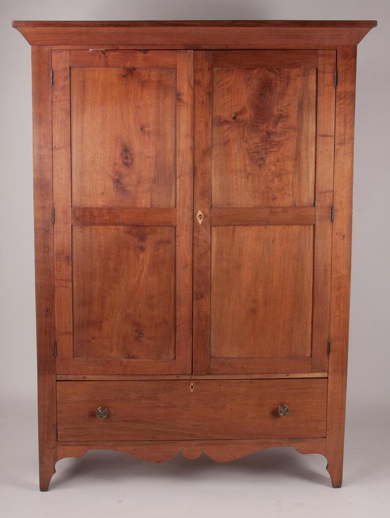 NORTH CAROLINA / VIRGINIA LATE FEDERAL WALNUT WARDROBE: NORTH CAROLINA / VIRGINIA LATE FEDERAL WALNUT WARDROBE / LINEN PRESS, angled cornice above two double-panel doors and a full-length lower drawer, the whole raised on tall cut-out feet centering a bold