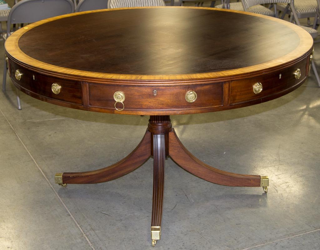 GEORGIAN-STYLE BANDED MAHOGANY CENTER DRUM-TOP TABLE: GEORGIAN-STYLE BANDED MAHOGANY CENTER DRUM-TOP TABLE, in two sections, top with four working frieze drawers, raised on a reeded pedestal and four down-swept legs terminating in brass caps and casters.