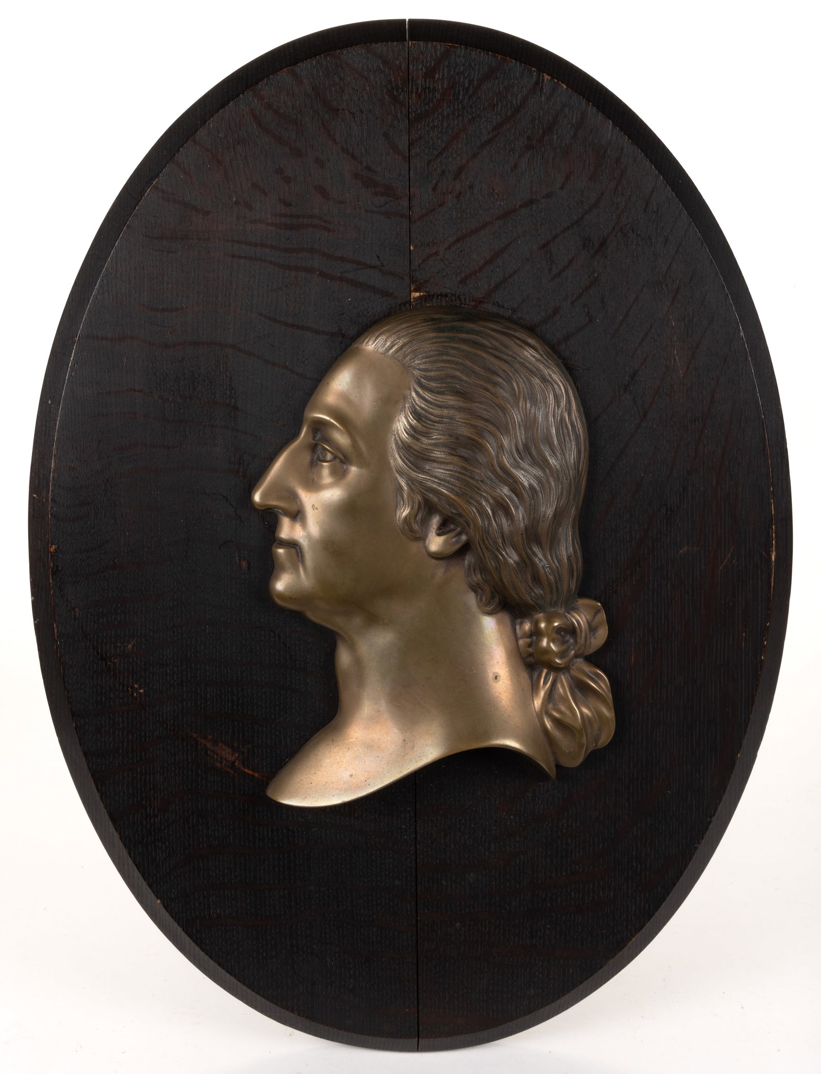GEORGE WASHINGTON BRONZE BAS-RELIEF PLAQUE: GEORGE WASHINGTON BRONZE BAS-RELIEF PLAQUE, the left-facing profile with ribbon-tied hair, mounted on an oval oak two-board back, not signed. Probably produced in 1932 for the bicentennial
