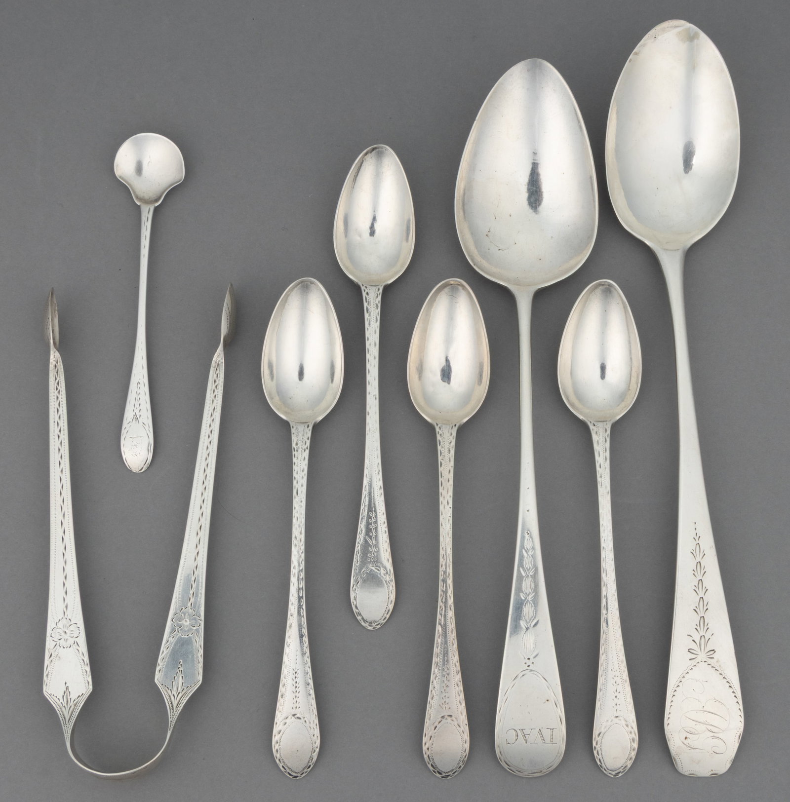 PHILADELPHIA, PENNSYLVANIA AND OTHER ENGRAVED-DECORATED COIN SILVER SPOONS AND SUGAR TONGS, LOT OF: PHILADELPHIA, PENNSYLVANIA AND OTHER ENGRAVED-DECORATED COIN SILVER SPOONS AND SUGAR TONGS, LOT OF SEVEN, each piece with bright-cut engraved decoration to handle; comprising a set of four teaspoons b