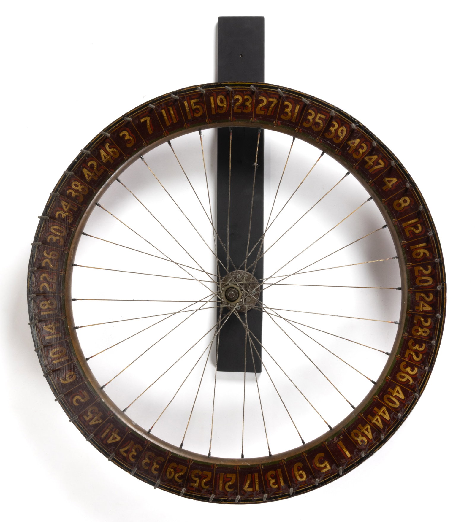 AMERICAN FOLK ART PAINTED WOODEN GAMING WHEEL: AMERICAN FOLK ART PAINTED WOODEN GAMING WHEEL, typical wall-mounted form with wooden frame attached to a bicycle wheel, featuring yellow and red numbers against a deep burgundy ground, retaining 
