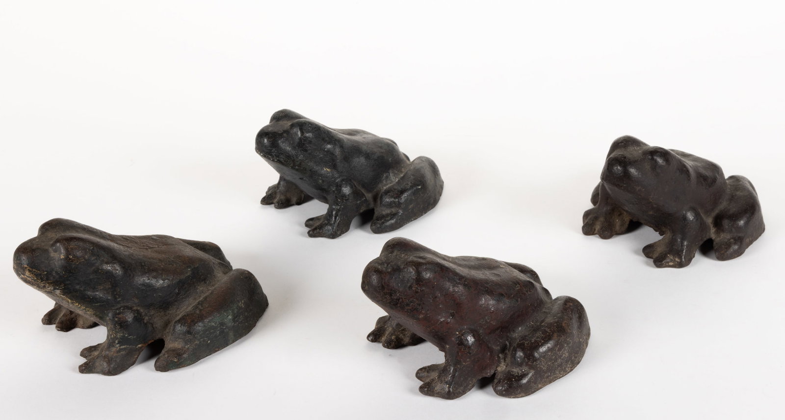 ASSORTED CAST-IRON FIGURAL FROG DOOR STOPS, LOT OF FOUR: ASSORTED CAST-IRON FIGURAL FROG DOOR STOPS, LOT OF FOUR, each of solid form and in sitting position, retains original painted finish. Early 20th century. 3" HOA, 3 1/2" x 5 1/2" overall