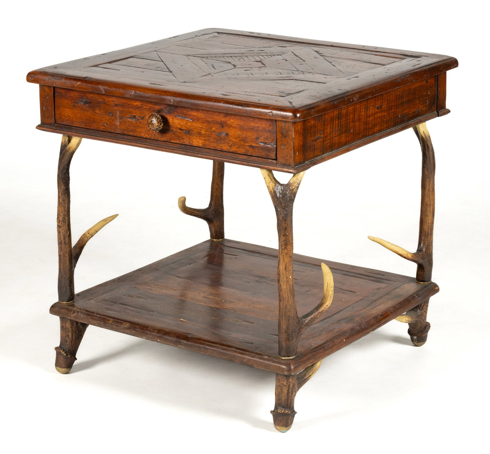 THEODORE ALEXANDER CASTLE BROMWICH RUSTIC ANTLER SIDE TABLE: THEODORE ALEXANDER CASTLE BROMWICH RUSTIC ANTLER SIDE TABLE, the square parquetry top over a single full drawer and a medial shelf, the whole supported by faux antler legs and feet. Retains original
