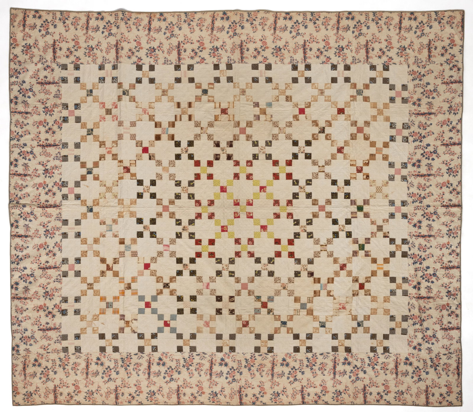 AMERICAN "NINE PATCH" PIECED QUILT: AMERICAN "NINE PATCH" PIECED QUILT, hand-stitched, completed in polychrome print and woven fabrics with solid white fabric, 135 pattern blocks alternating with plain whole blocks to create