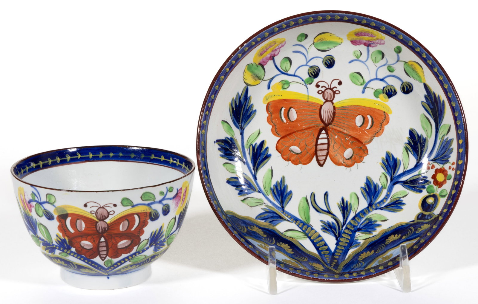 ENGLISH PEARLWARE GAUDY DUTCH BUTTERFLY MOTIF CERAMIC CUP AND SAUCER SET: ENGLISH PEARLWARE GAUDY DUTCH BUTTERFLY MOTIF CERAMIC CUP AND SAUCER SET, each having bold polychrome Butterfly pattern. First quarter 19th century. 2 1/4" HOA, 5 1/2" D sauce