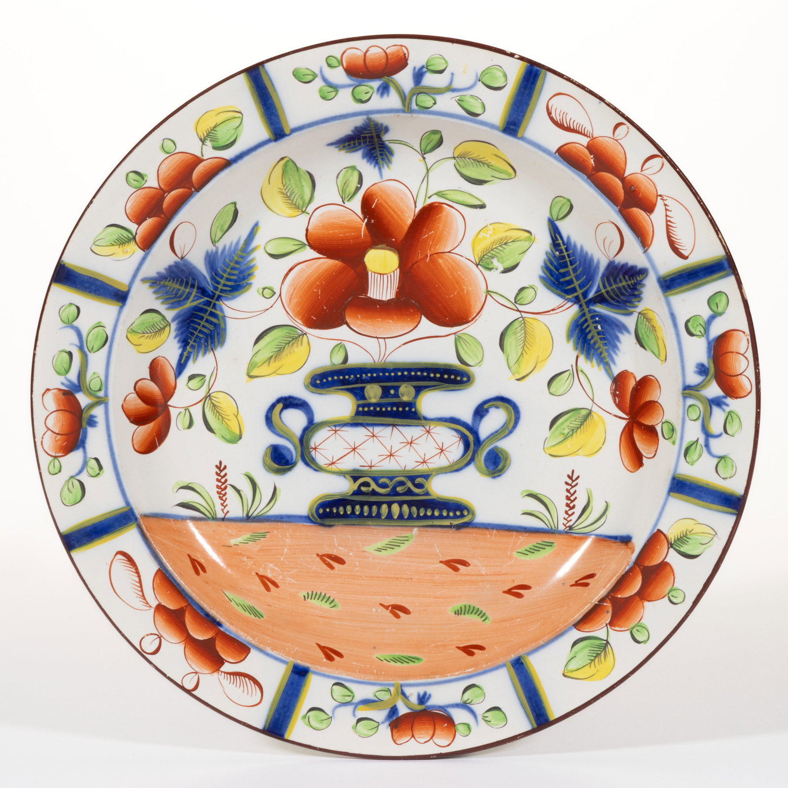 ENGLISH PEARLWARE HAND-PAINTED GAUDY DUTCH CERAMIC PLATE: ENGLISH PEARLWARE HAND-PAINTED GAUDY DUTCH CERAMIC PLATE, featuring bold polychrome Urn floral decoration. Unmarked. First quarter 19th century. 9 7/8" D. Literature: Parallels the Foxe