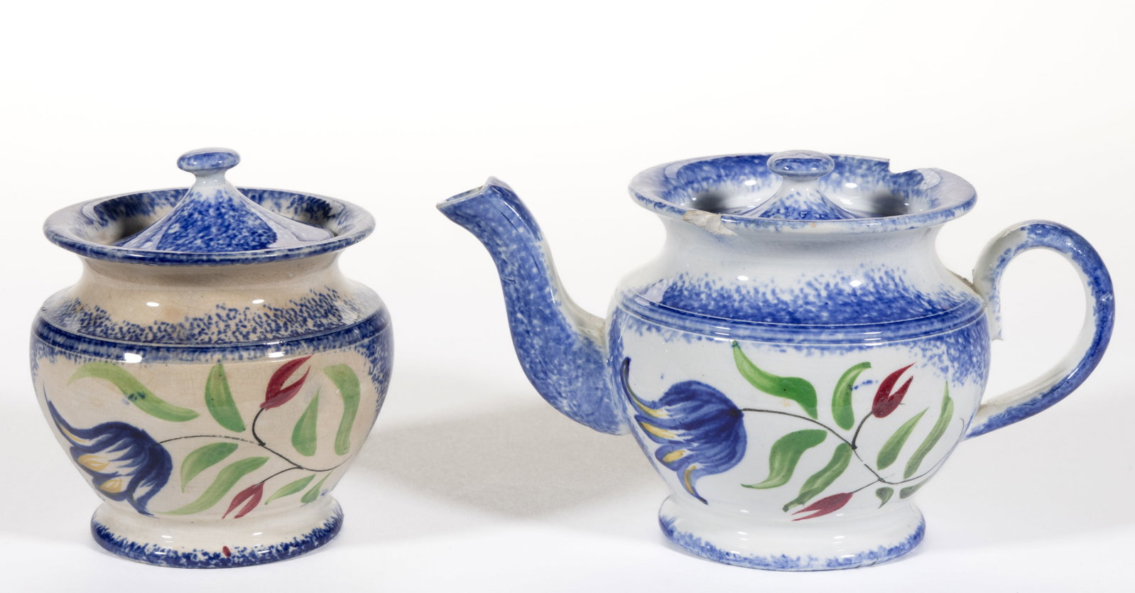 ENGLISH SPATTERWARE FLORAL MOTIF CERAMIC CHILDREN'S TOY TEA ARTICLES, LOT OF TWO: ENGLISH SPATTERWARE FLORAL MOTIF CERAMIC CHILDREN'S TOY TEA ARTICLES, LOT OF TWO, each featuring a charming polychrome hand-painted tulip with additional buds on a green-foliated stem, h