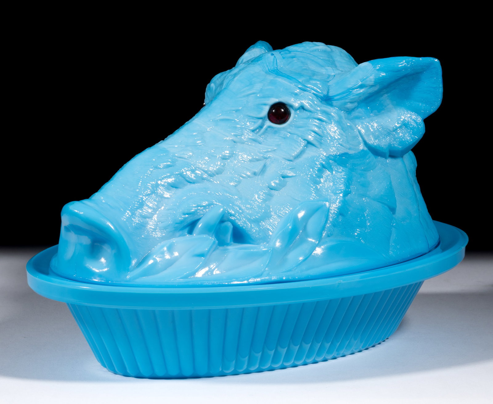BOAR'S HEAD COVERED DISH: BOAR'S HEAD COVERED DISH, opaque blue, applied ruby eyes, interior lid and under base embossed "PATENTED". Atterbury & Co. Circa 1888. 5 1/2" HOA, 6 1/4" x 9 3/8" D. L