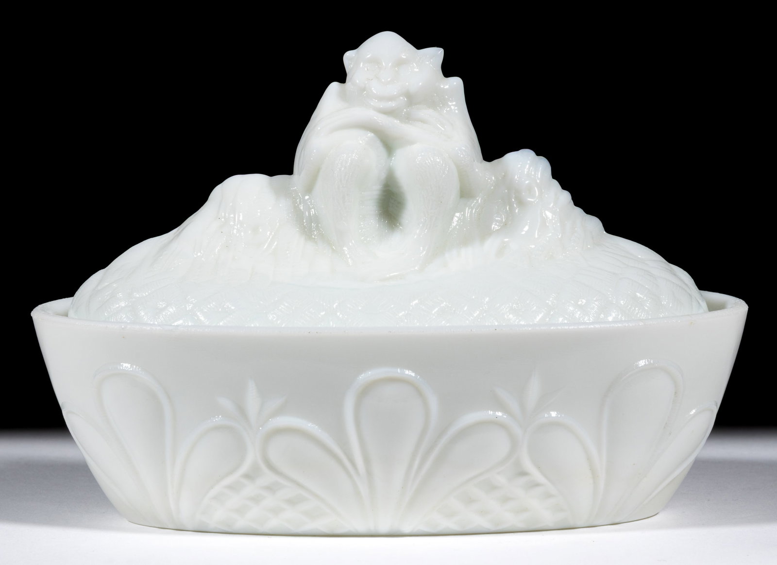FLACCUS BABOON COVERED DISH: FLACCUS BABOON COVERED DISH, opaque white/milk glass, fleur-de-lys base. First quarter 20th century. 4 1/4" HOA, 3 1/2" x 6" base rim. Literature: Parallels the Fersons - Yesterday'