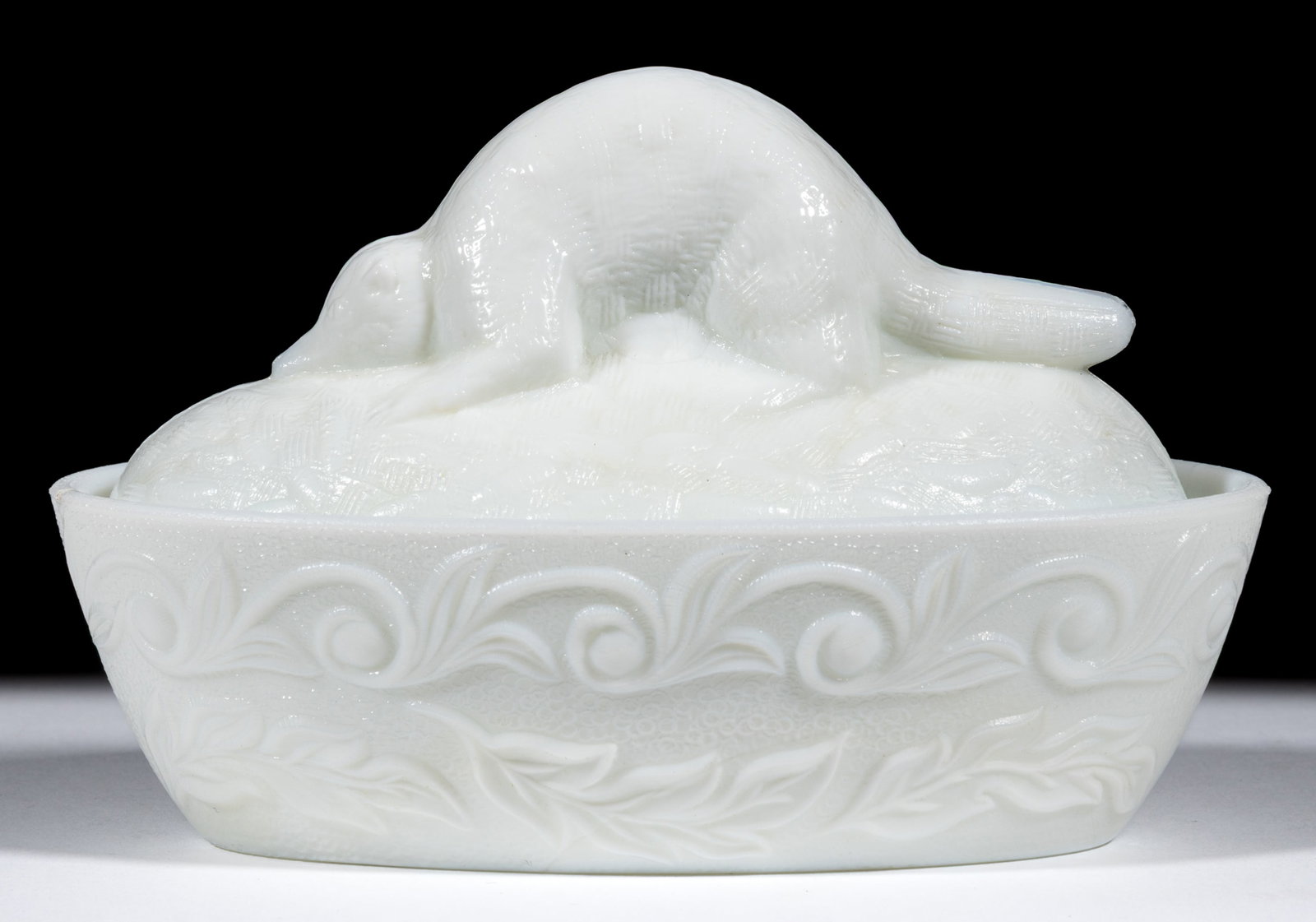 FLACCUS BEAVER COVERED DISH: FLACCUS BEAVER COVERED DISH, opaque white/milk glass, scroll and leaf base. Fourth quarter 19th century. 4" HOA, 3 1/2" x 6 1/8". Literature: Parallels the Fersons - Yesterday'