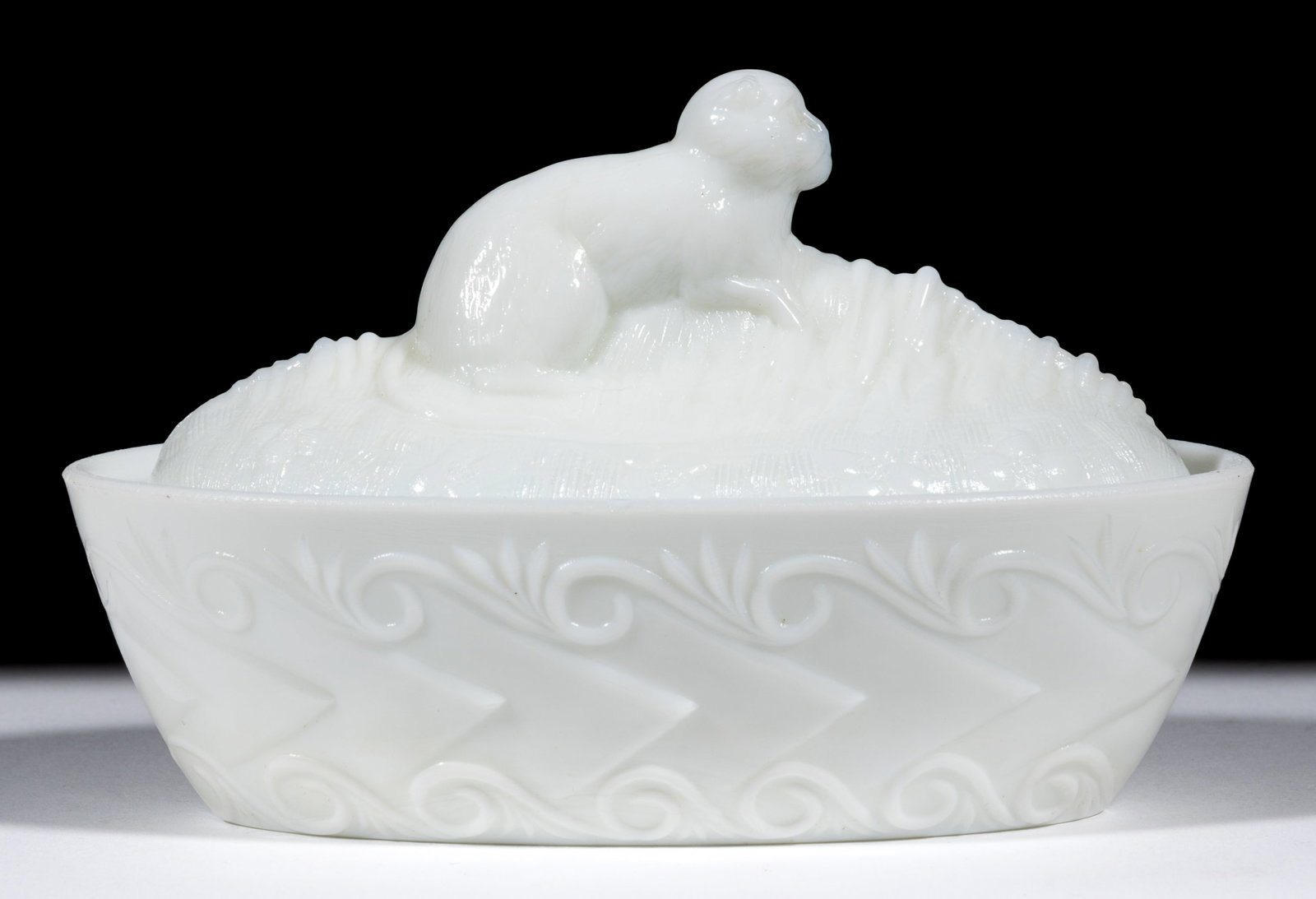 FLACCUS MONKEY COVERED DISH: FLACCUS MONKEY COVERED DISH, opaque white/milk glass, arrow and scroll base. Fourth quarter 19th century. 4" HOA, 3 1/2" x 6 1/8". Literature: Parallels the Fersons - Yesterday