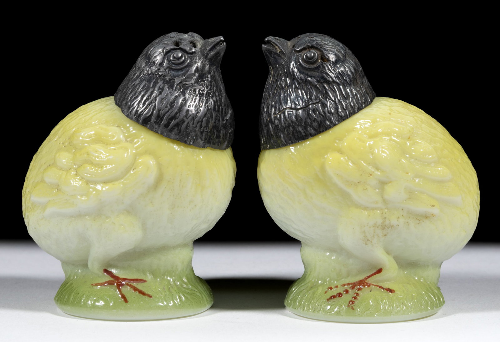 CHICK ON PEDESTAL FIGURAL SALT AND PEPPER SHAKERS: CHICK ON PEDESTAL FIGURAL SALT AND PEPPER SHAKERS, opal white with a yellow and green ground enamel decoration, each having original cover. C. F. Monroe Co. Circa 1903. 2 7/8" HOA.