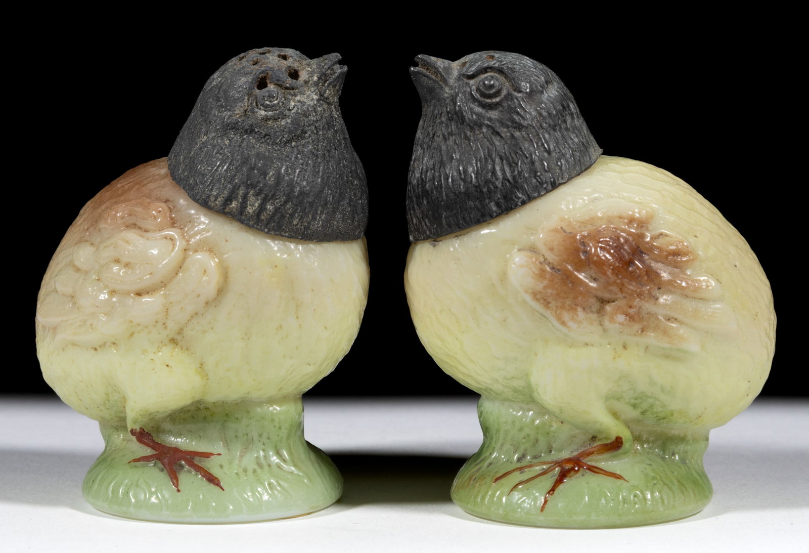 CHICK ON PEDESTAL FIGURAL SALT AND PEPPER SHAKERS: CHICK ON PEDESTAL FIGURAL SALT AND PEPPER SHAKERS, opal white with a tan and green ground enamel decoration, each having original cover. C. F. Monroe Co. Circa 1903. 2 7/8" HOA. 