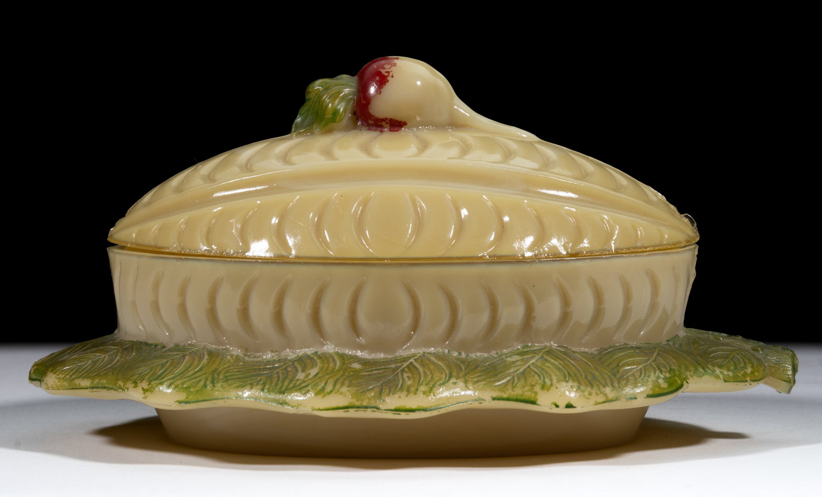 MELON COVERED BUTTER DISH WITH RADISH FINIAL: MELON COVERED BUTTER DISH WITH RADISH FINIAL, opaque caramel with original paint decoration. Maker unverified. Late 19th/early 20th century. 4" HOA, 5 1/2" x 7 3/4". Literatu