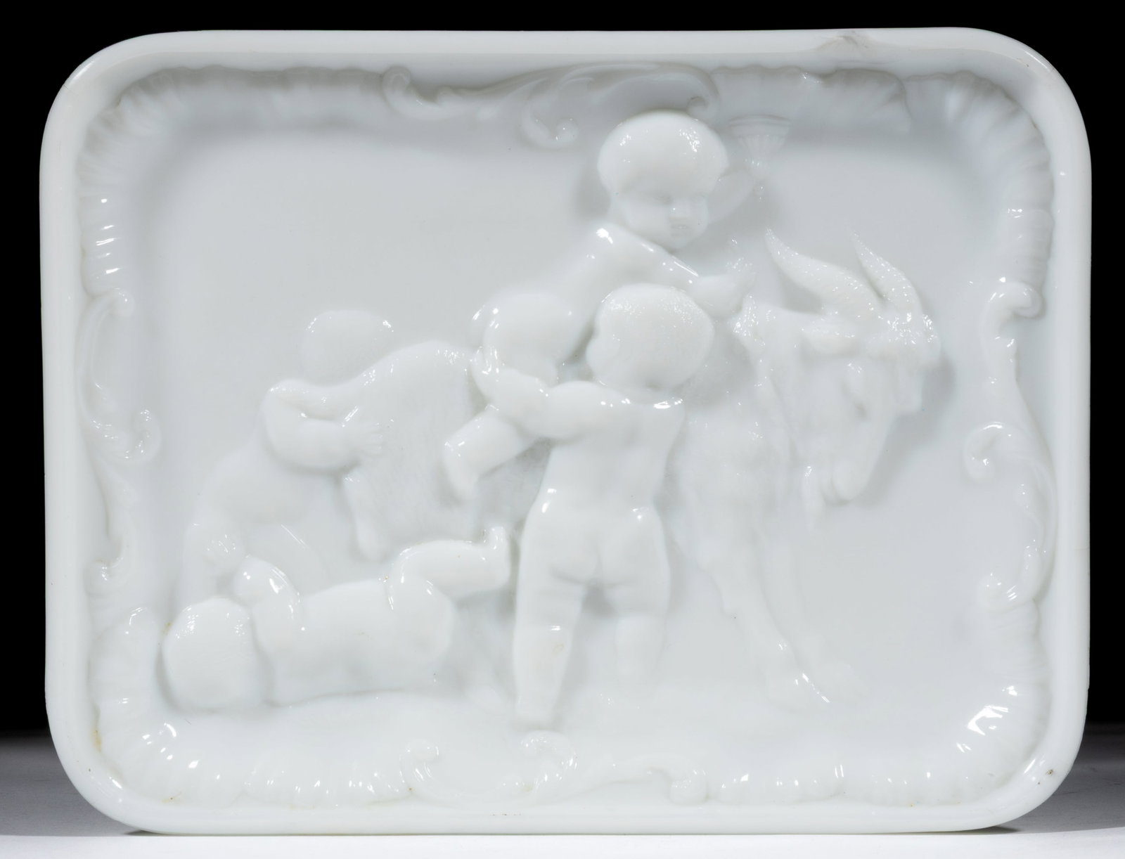 CHILDREN AND GOAT TRAY: CHILDREN AND GOAT TRAY, opaque white/milk glass, high relief of four very young children playing with a goat. Probably English. Fourth quarter 19th/early 20th century. 7 3/4" x 10 1/8".