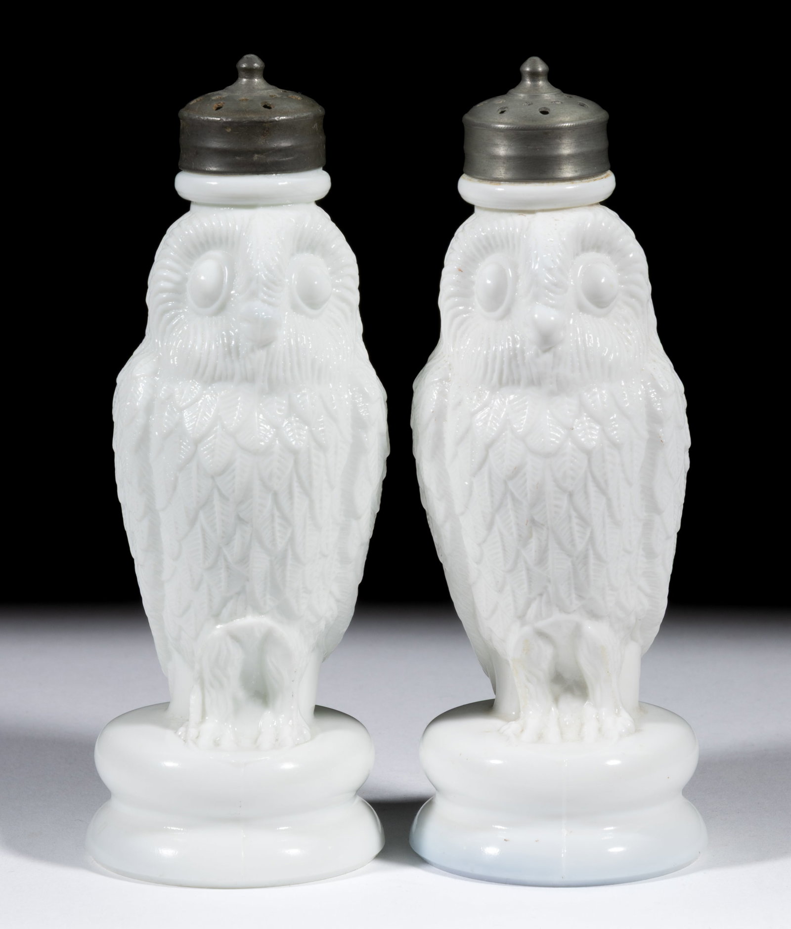 BIG OWL FIGURAL PRESSED GLASS SALT AND PEPPER SHAKERS: BIG OWL FIGURAL PRESSED GLASS SALT AND PEPPER SHAKERS, an opaque white/milk glass, each having a period cover. Maker unverified. 1884-1891. 6" HOA. Literature: Parallels Lechner - The