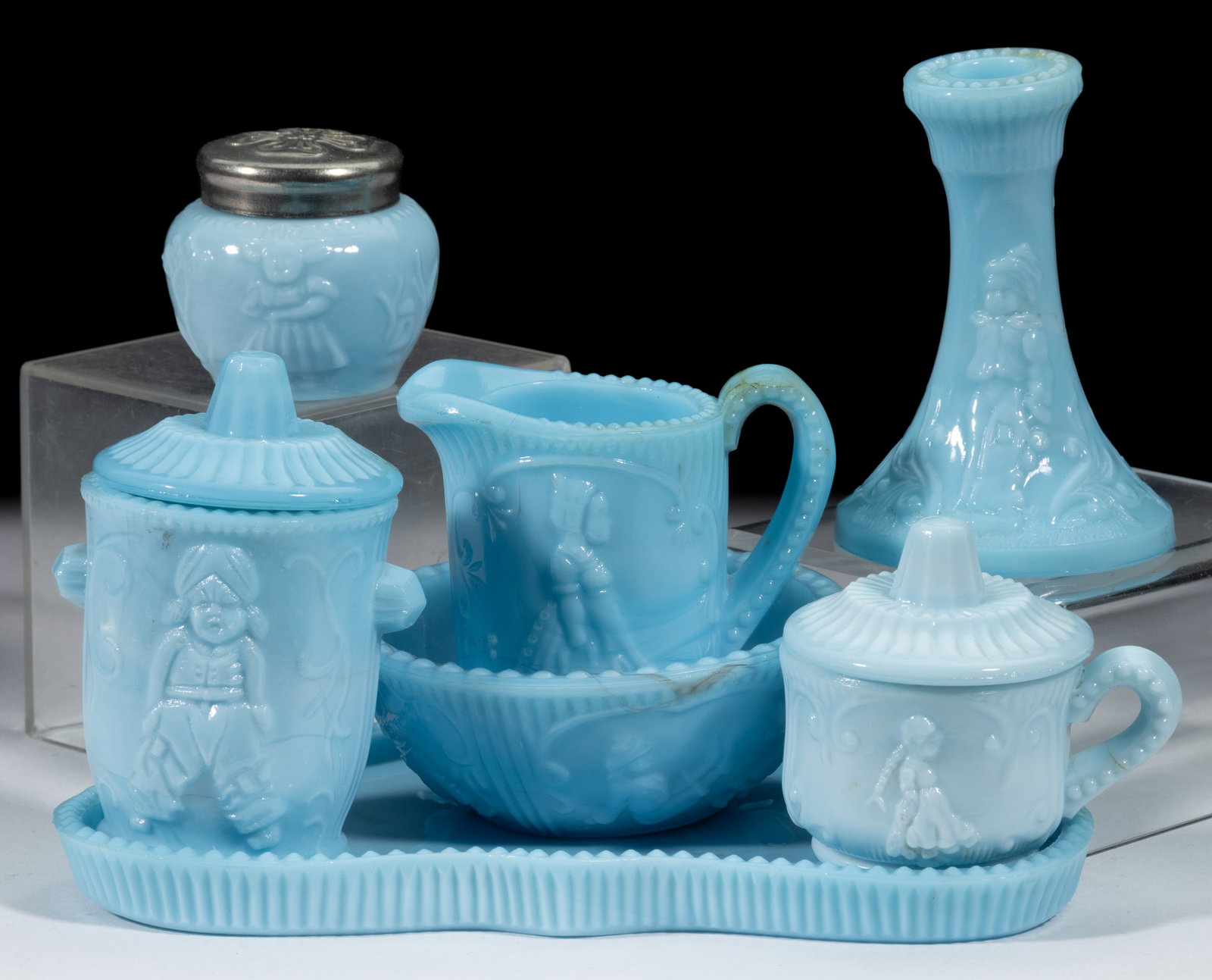 DUTCH BOUDOIR CHILDREN'S GLASS TOY ARTICLES, LOT OF SEVEN: DUTCH BOUDOIR CHILDREN'S GLASS TOY ARTICLES, LOT OF SEVEN, opaque blue, including a pomade jar, pitcher, candlestick, wash basin, chamber pot, and tray. U.S. Glass Co. Circa 1910. 1 5/8"