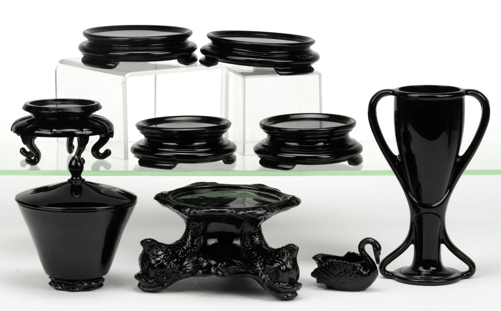 ASSORTED OPAQUE BLACK GLASS ARTICLES, LOT OF NINE: ASSORTED OPAQUE BLACK GLASS ARTICLES, LOT OF NINE, opaque black amethyst, comprising a Fostoria Diadem covered candy dish, a Fostoria Tut vase, a Swan open salt, and six display bases. Vario