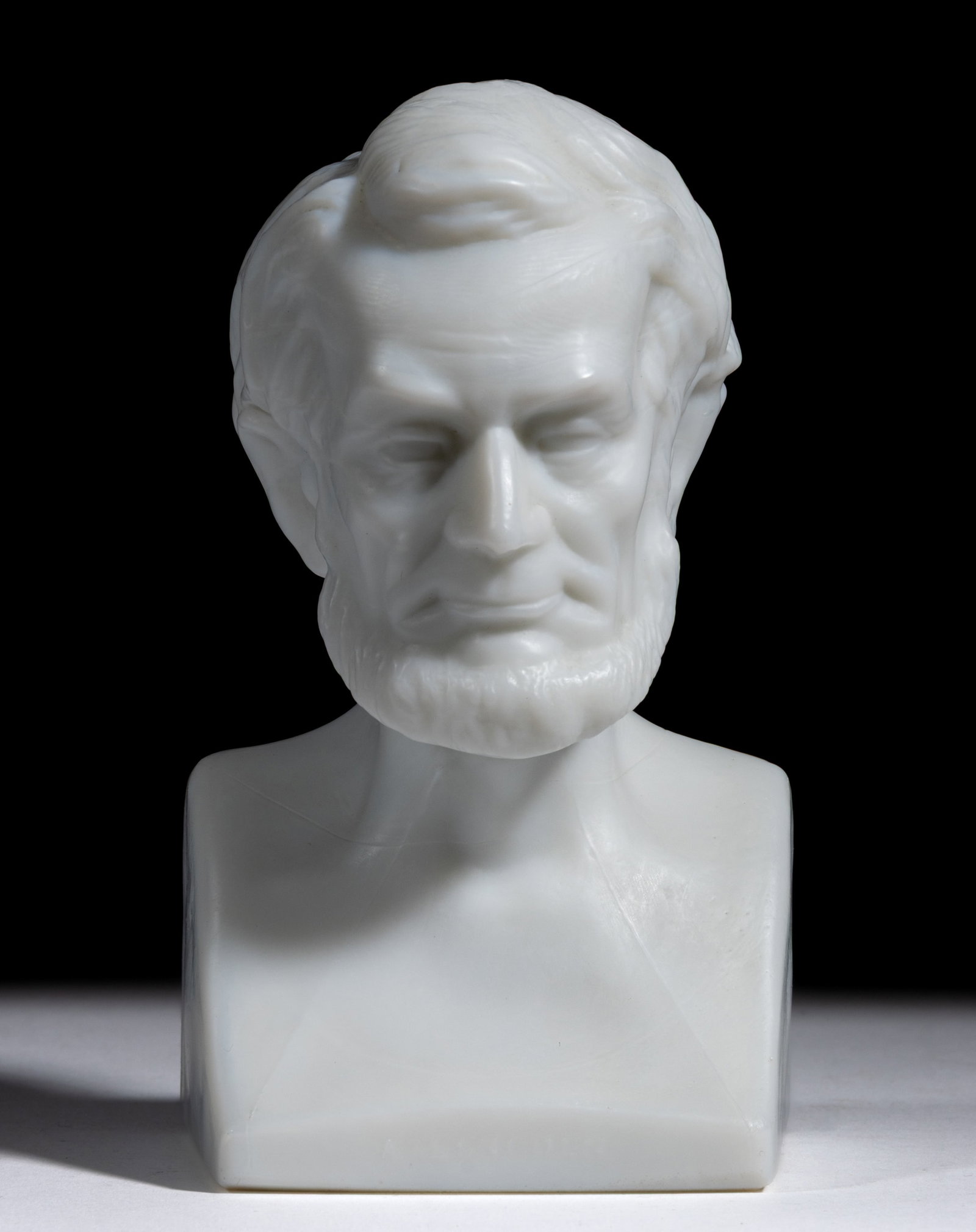 1876 PHILADELPHIA CENTENNIAL GLASS FIGURAL ABRAHAM LINCOLN BUST / PAPERWEIGHT: 1876 PHILADELPHIA CENTENNIAL GLASS FIGURAL ABRAHAM LINCOLN BUST / PAPERWEIGHT, opaque white/milk glass with satin surface, solid shoulder-length bust or statuette of the President with square-form bas