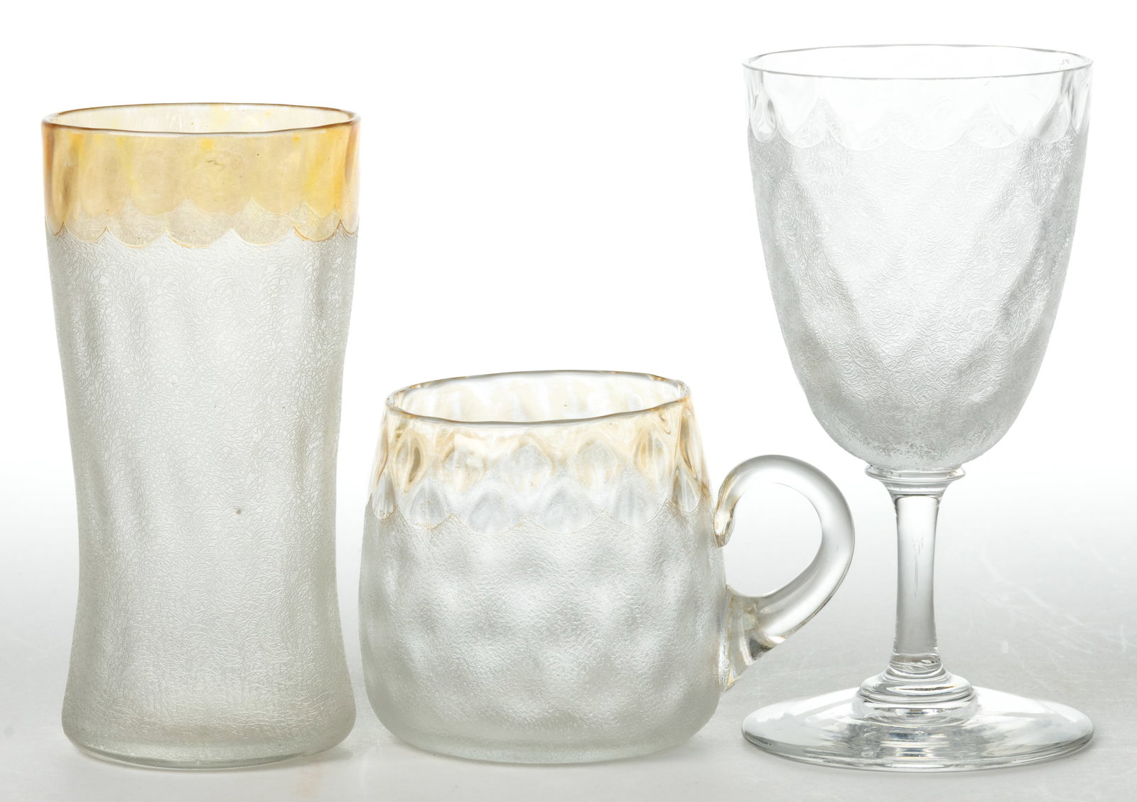 POMONA - FIRST-PATENT ETCHING ART GLASS DRINKING VESSELS, LOT OF THREE: POMONA - FIRST-PATENT ETCHING ART GLASS DRINKING VESSELS, LOT OF THREE, colorless, two with amber iridescence, each with Diamond-Optic molding, comprising a champagne glass with spool stem, a pun