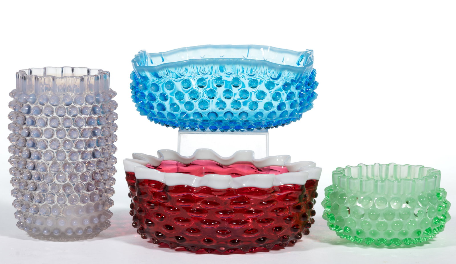 ASSORTED HOBBS NO. 323 DEW DROP / HOBNAIL GLASS ARTICLES, LOT OF FOUR: ASSORTED HOBBS NO. 323 DEW DROP / HOBNAIL GLASS ARTICLES, LOT OF FOUR, comprising a cranberry berry bowl with an applied opal rim, a sapphire opalescent square berry bowl, an opalescent celery vase, a