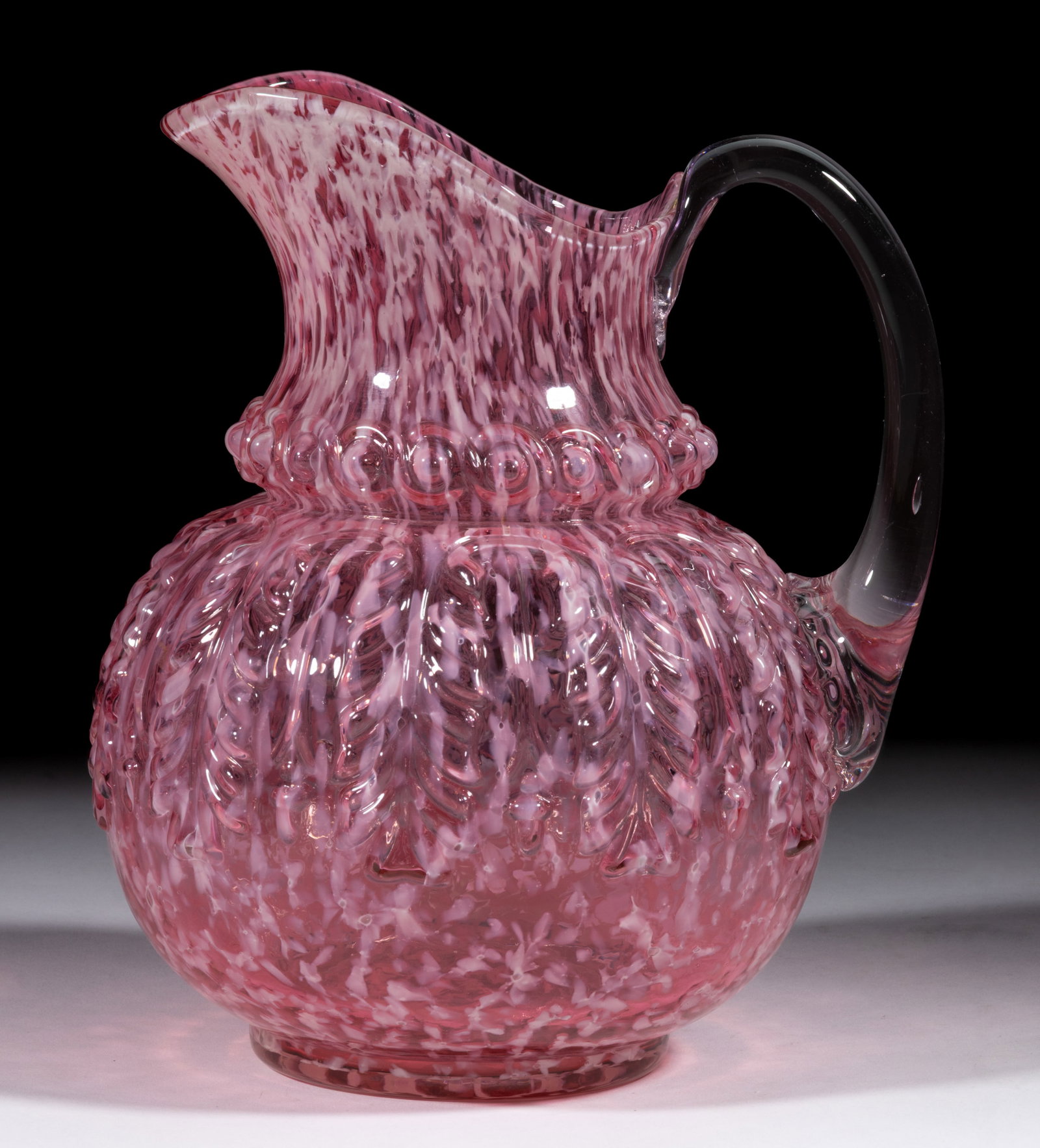 NORTHWOOD NO. 263 / LEAF UMBRELLA WATER PITCHER: NORTHWOOD NO. 263 / LEAF UMBRELLA WATER PITCHER, Ruby with opal splatter, applied colorless handle. H. Northwood Glass Co. Pattern introduced 1889. 9" H. Literature: Parallels Heacock/Measel