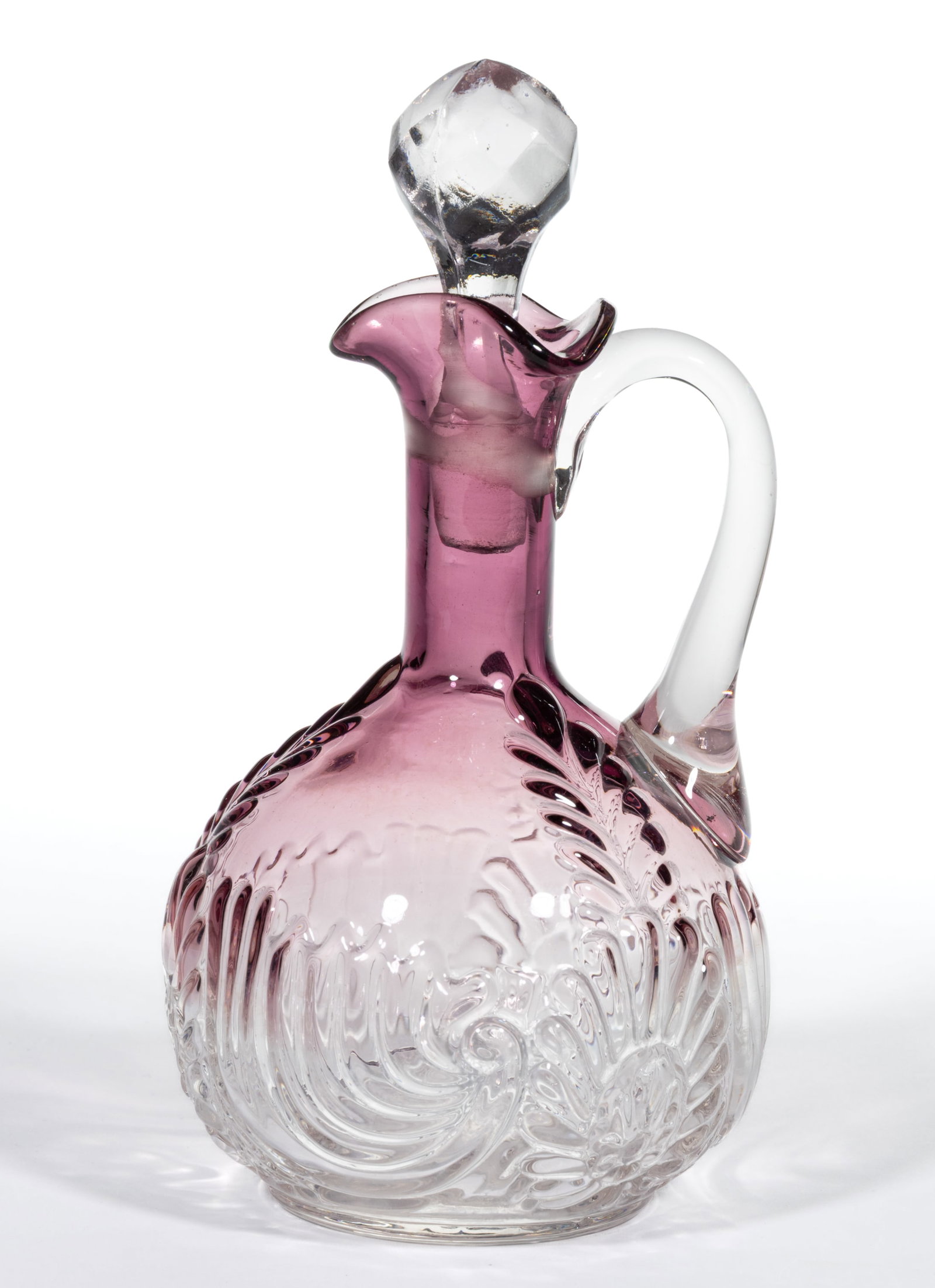 MEDALLION SPRIG CRUET: MEDALLION SPRIG CRUET, amethyst shaded to colorless, tri-fold spout, colorless applied handle, and cut-faceted stopper. West Virginia Glass Co. Circa 1894. 7" HOA. Literature: Parallels Heac