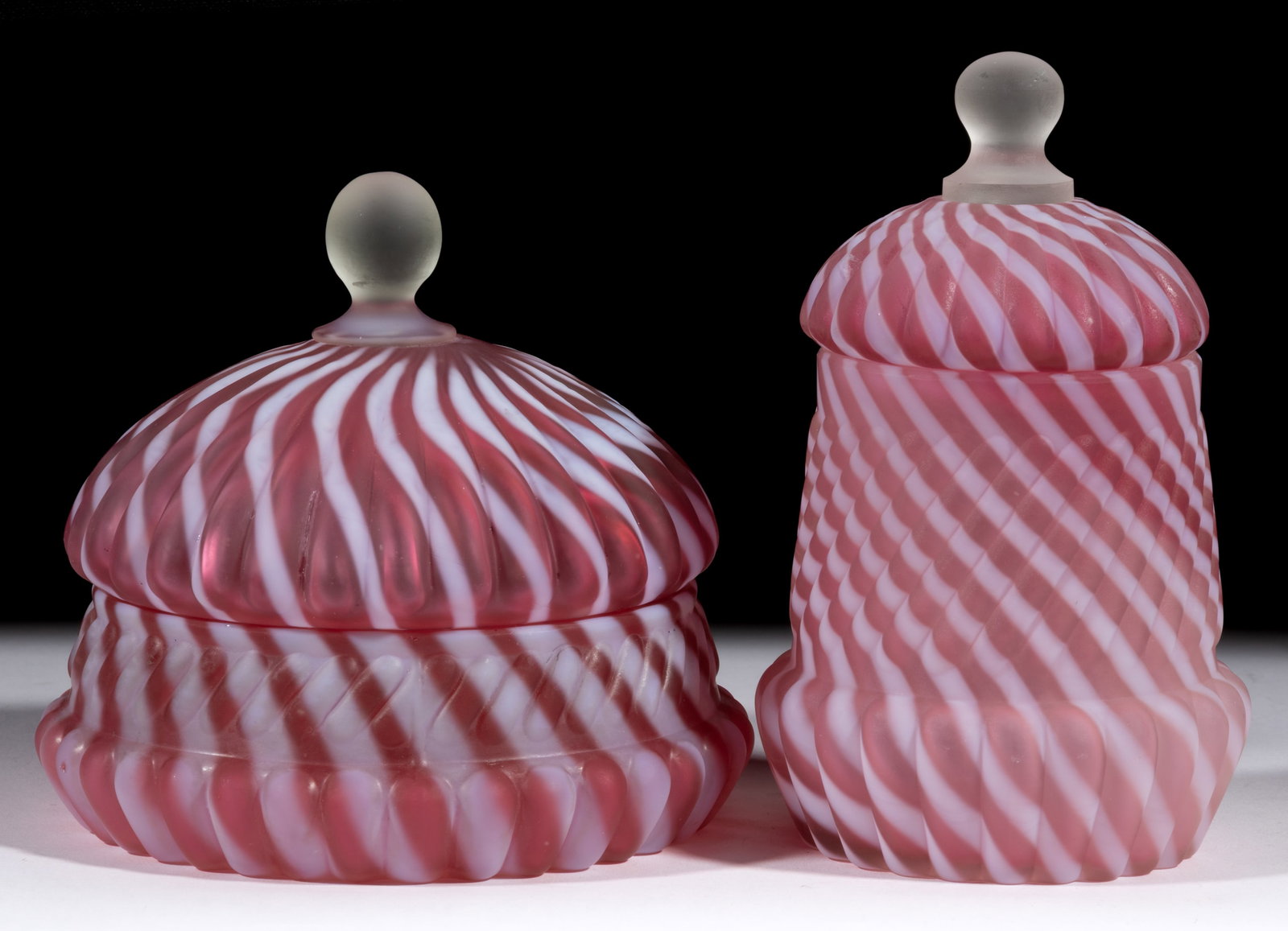 NORTHWOOD NO. 229 / CHRYSANTHEMUM SWIRL TABLE ARTICLES, LOT OF TWO: NORTHWOOD NO. 229 / CHRYSANTHEMUM SWIRL TABLE ARTICLES, LOT OF TWO, cranberry opalescent with satin finish, comprising covered sugar bowl and butter dish, both covers with colorless applied ball-form 