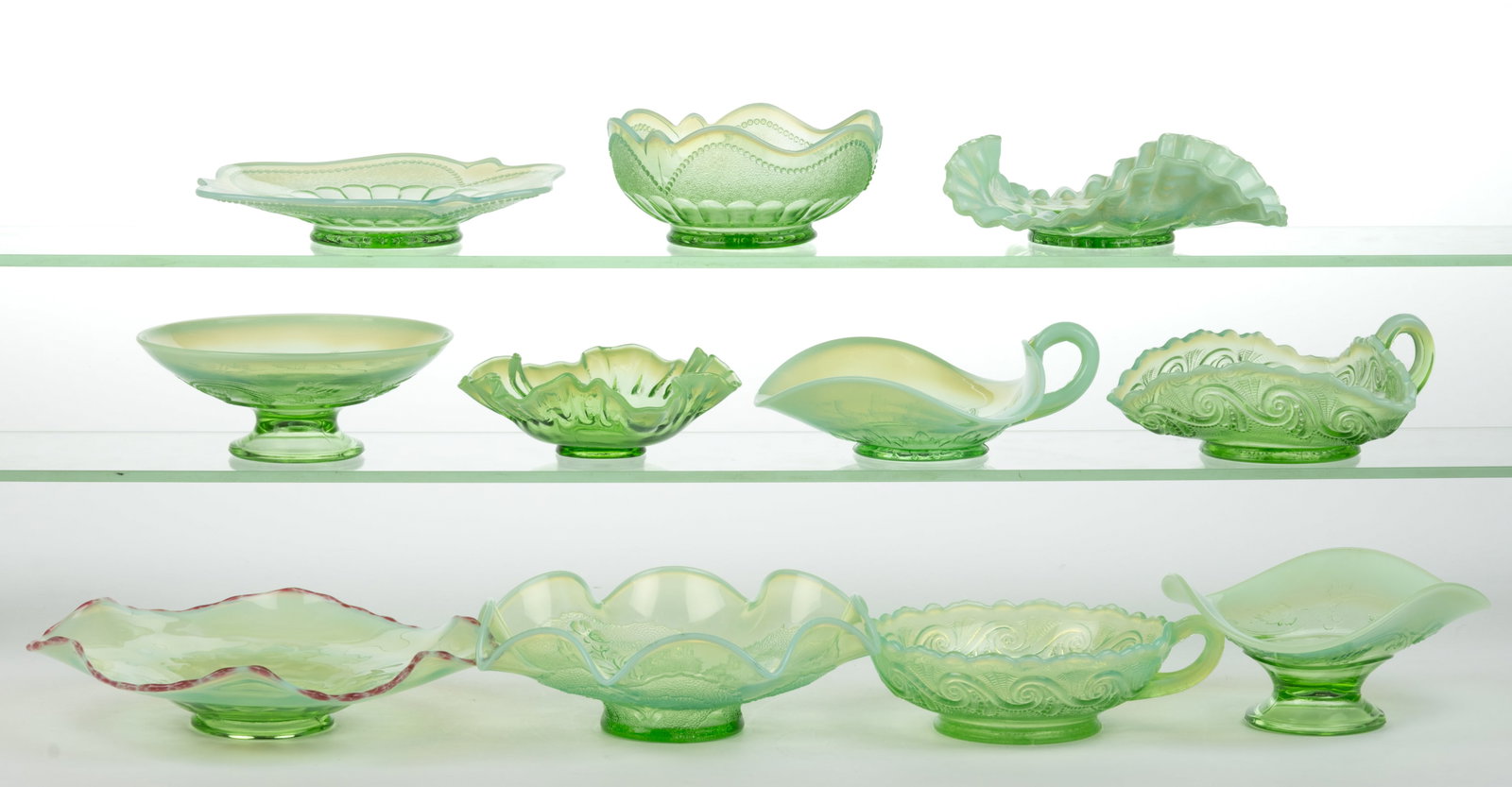 ASSORTED OPALESCENT GLASS ARTICLES, LOT OF 11: ASSORTED OPALESCENT GLASS ARTICLES, LOT OF 11, green opalescent, comprising a Dugan Daisy May handled bon-bon jar, Blocked Thumbprint & Beads plate and sauce dish, Laura bowl, Victory (OMN) nappy,