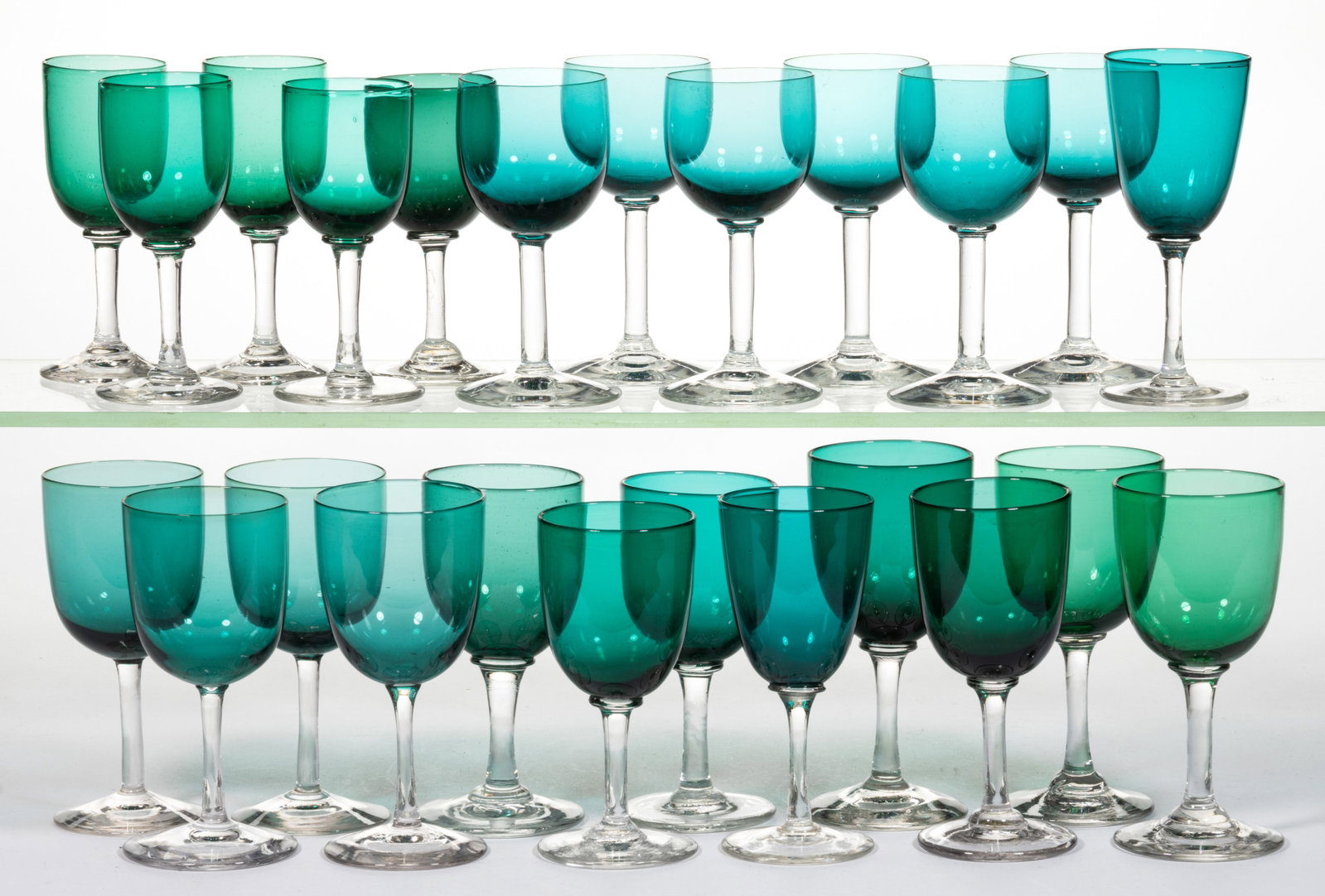 ASSORTED FREE-BLOWN WINES, LOT OF 24: ASSORTED FREE-BLOWN WINES, LOT OF 24, green and colorless, each with cup-form bowl and plain stem, three with polished pontil mark. First half 20th century. 4 1/2" to 5 1/4" H