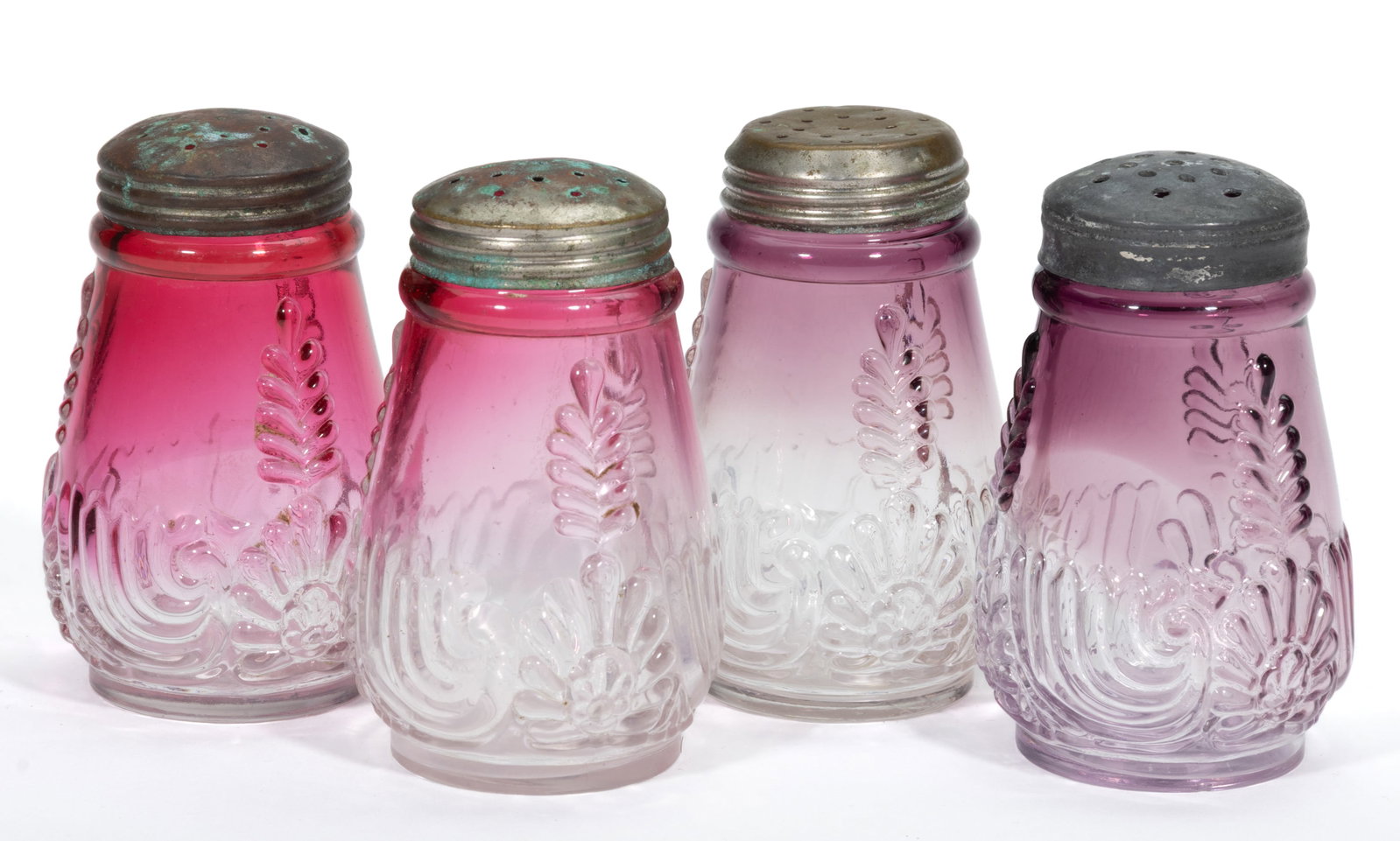 MEDALLION SPRIG SALT AND PEPPER SHAKERS, LOT OF FOUR: MEDALLION SPRIG SALT AND PEPPER SHAKERS, LOT OF FOUR, two shaded cranberry and two shaded amethyst, each with period lids. West Virginia Glass Co. Circa 1894. 3 1/2" HOA. Literature: Parall