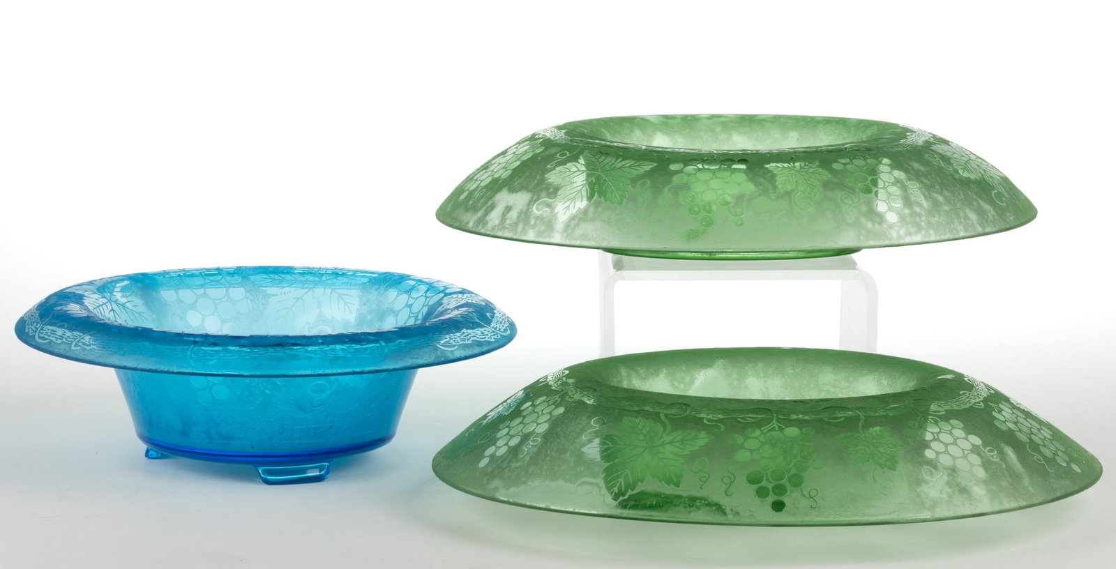 FOSTORIA GRAPE BROCADE ETCHED GLASS BOWLS, LOT OF THREE: FOSTORIA GRAPE BROCADE ETCHED GLASS BOWLS, LOT OF THREE, blue and apple green (reacts under black light), comprising a footed rolled-edge bowl and two oval rolled-edge console bowls. Circa 1