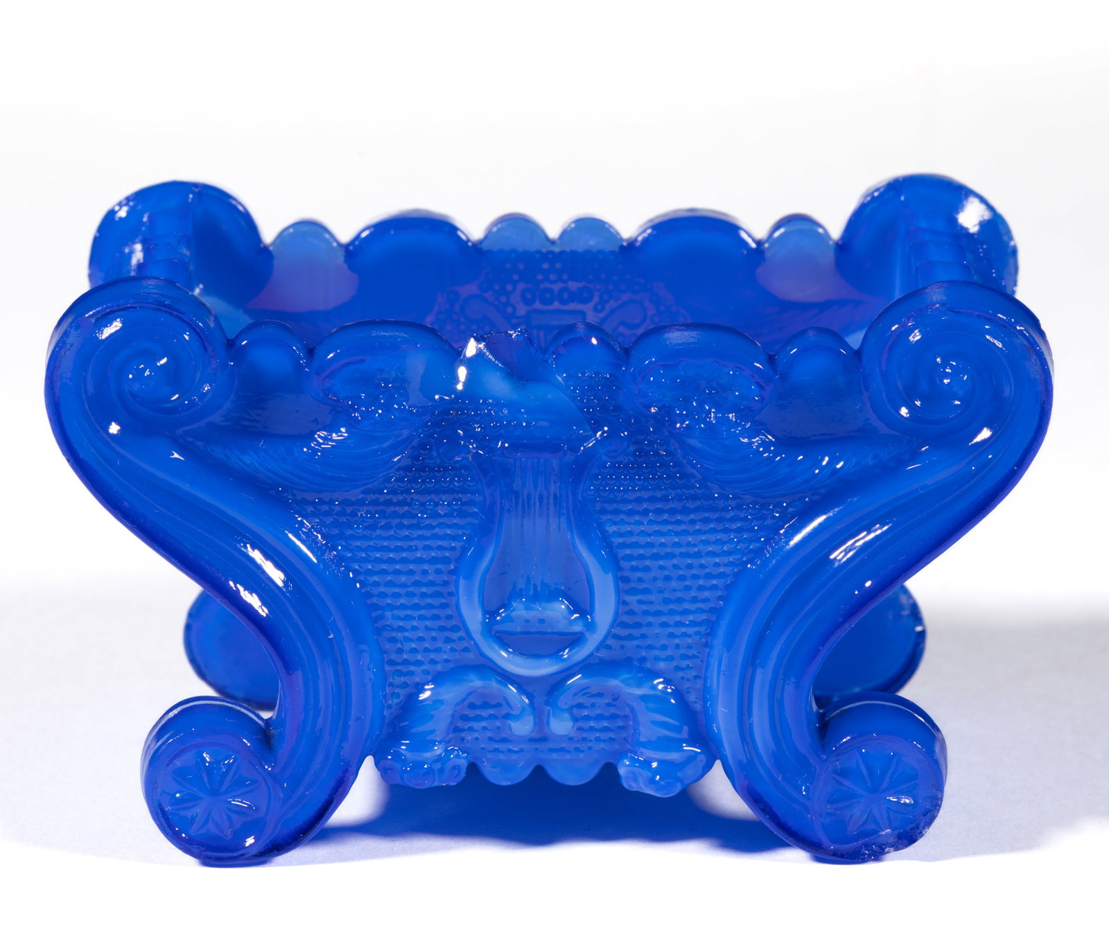 LE-3 LYRE PRESSED OPEN SALT: LE-3 LYRE PRESSED OPEN SALT, opalescent-opaque mottled medium blue, raised on four scroll feet. Very rare. Boston & Sandwich Glass Co. 1835-1845. 1 7/8" H, 2" x 3