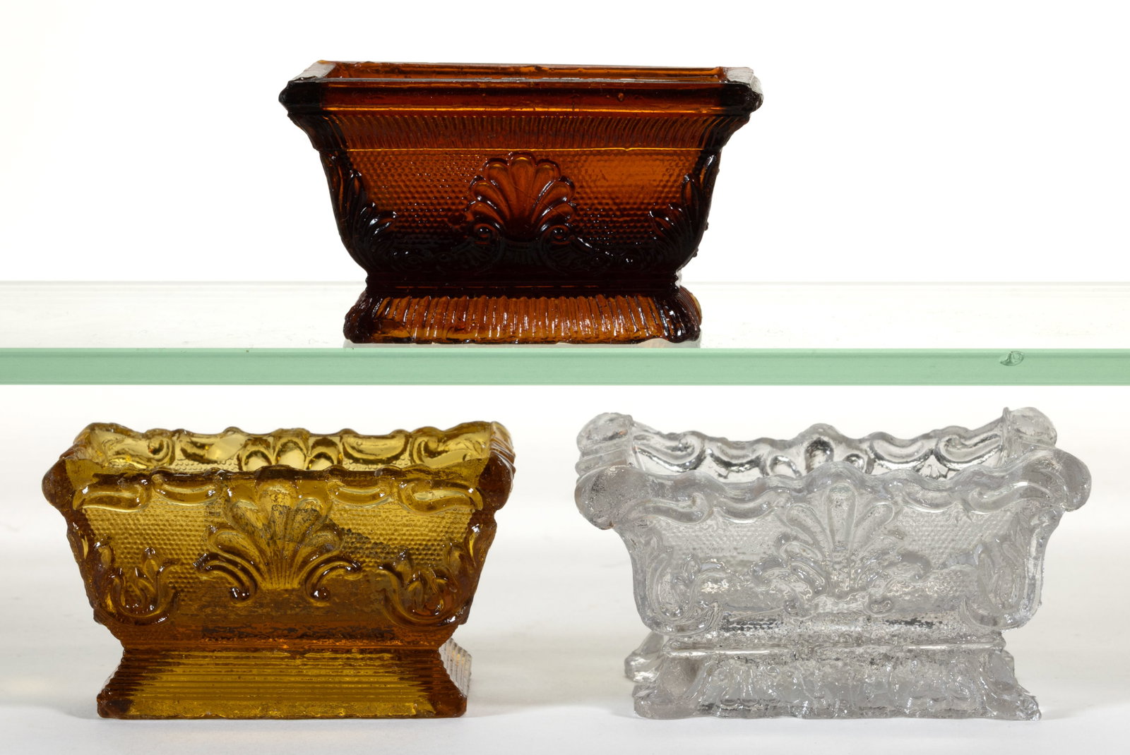 ASSORTED SL SHELL PRESSED OPEN SALTS, LOT OF THREE: ASSORTED SL SHELL PRESSED OPEN SALTS, LOT OF THREE, comprising a colorless SL-1b (see Acorn), a medium amber SL-8, and an unlisted amber SL-9. Unknown rarity, very rare, and probably very or extremely