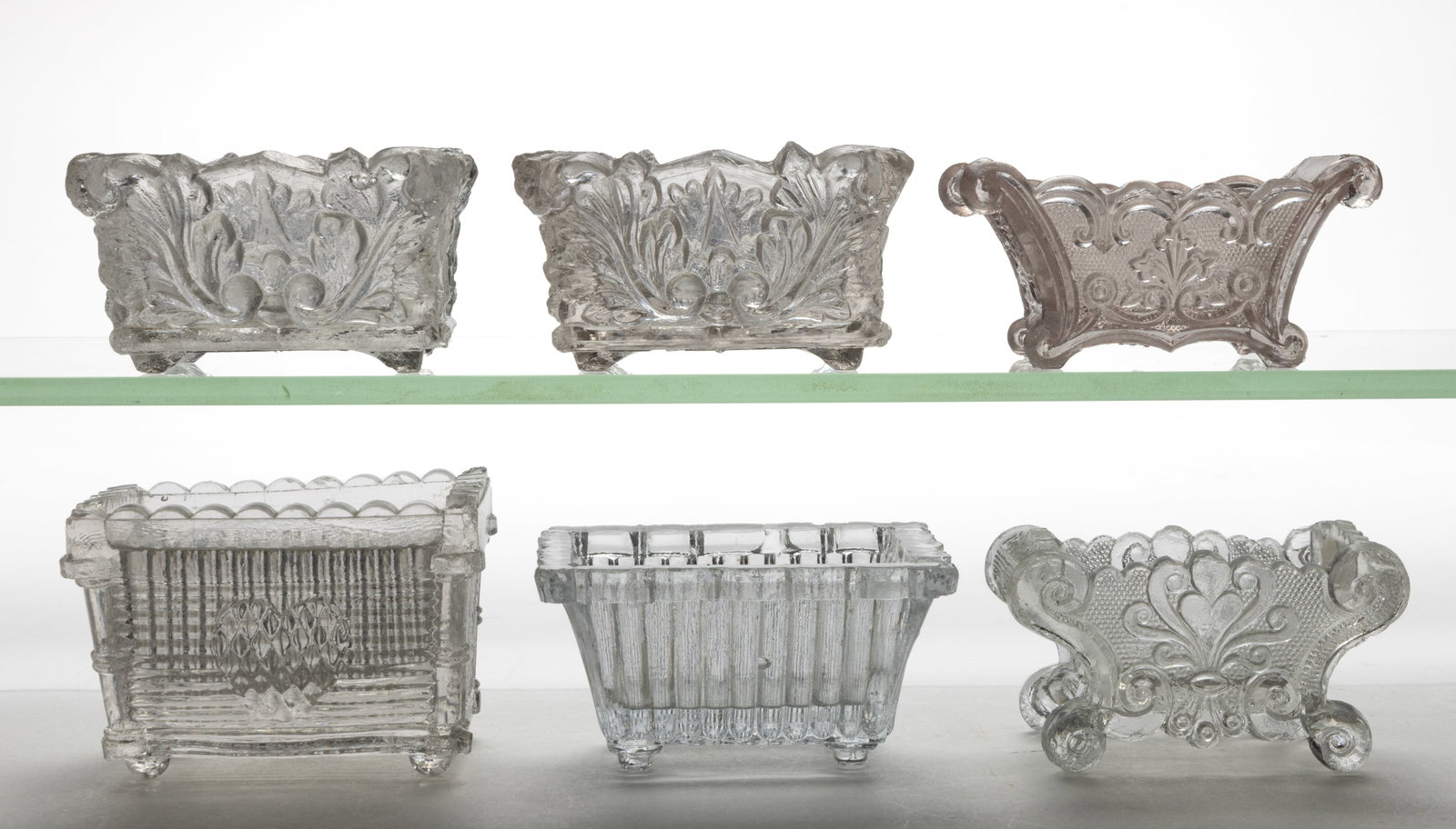 ASSORTED LACY-PERIOD PRESSED OPEN SALTS, LOT OF SIX: ASSORTED LACY-PERIOD PRESSED OPEN SALTS, LOT OF SIX, colorless, comprising OG-2, two OG-10, OG-16, SC-7, and SC-8 unlisted with pink tint. Scarce, rare, and unknown rarity. Various makers. 1830-1860.