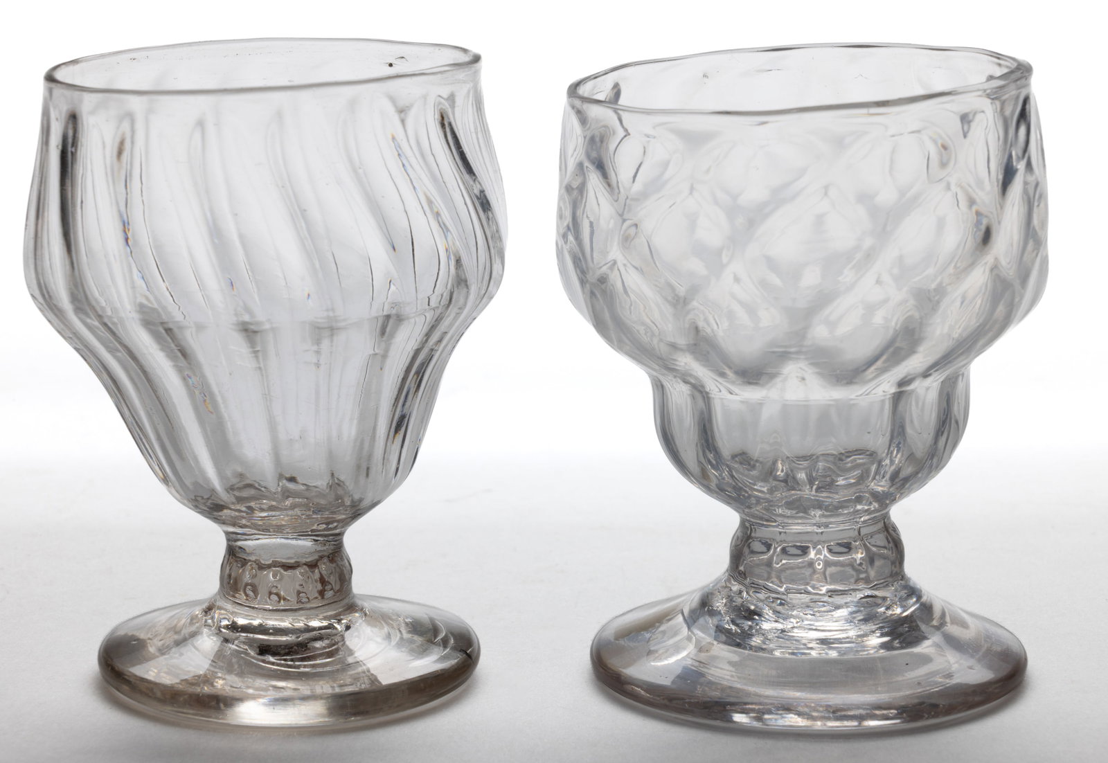 ASSORTED PATTERN-MOLDED FOOTED OPEN SALTS, LOT OF TWO: ASSORTED PATTERN-MOLDED FOOTED OPEN SALTS, LOT OF TWO, colorless, one with three rows of 12 diamonds over 12 flutes, the other with 16 slightly swirled vertical ribs, each with double-ogee bowl r