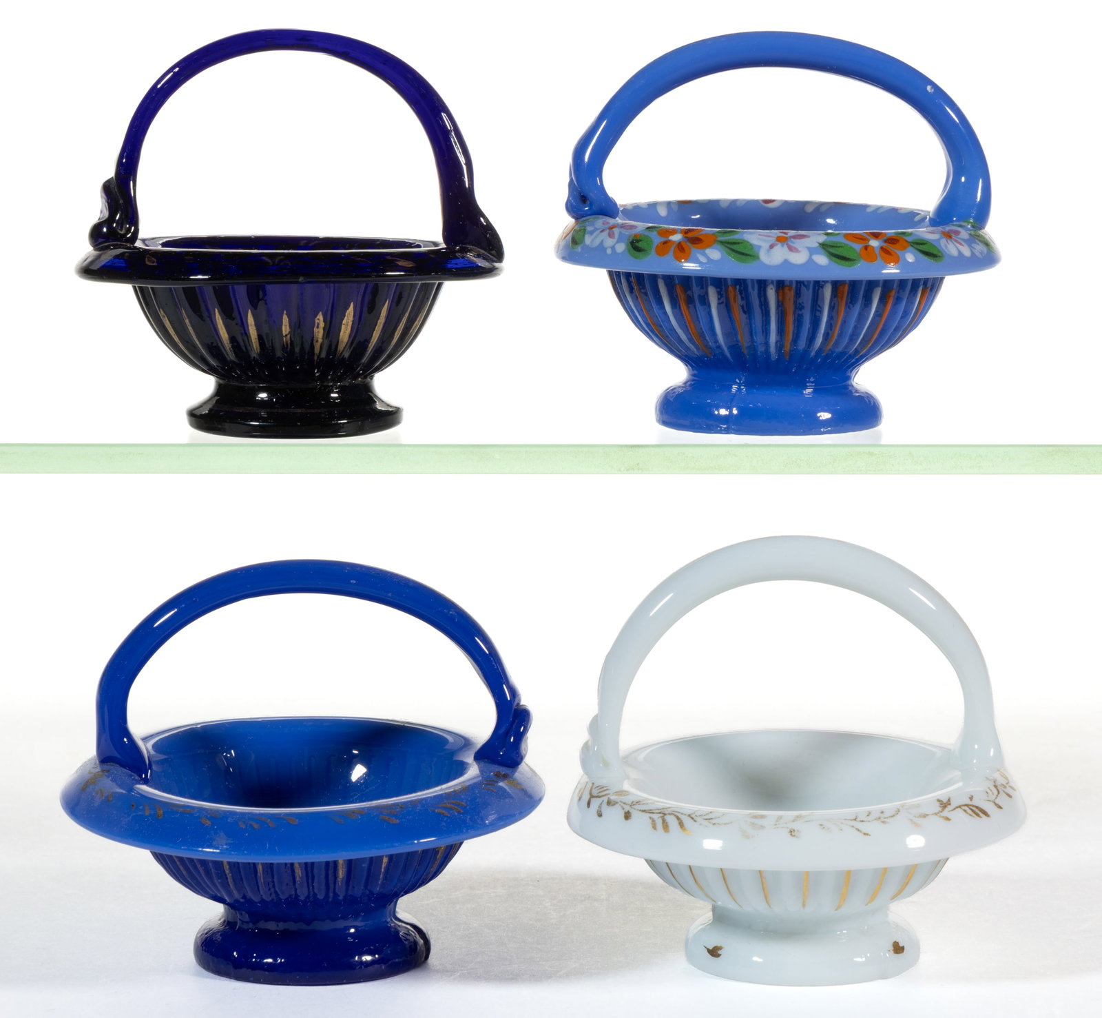BLOWN / PRESSURE-MOLDED OPAQUE GLASS BASKET OPEN SALTS, LOT OF FOUR: BLOWN / PRESSURE-MOLDED OPAQUE GLASS BASKET OPEN SALTS, LOT OF FOUR, various colors, each with gilt or polychrome-enamel decoration to rim, applied handle, and ribbed body on circular