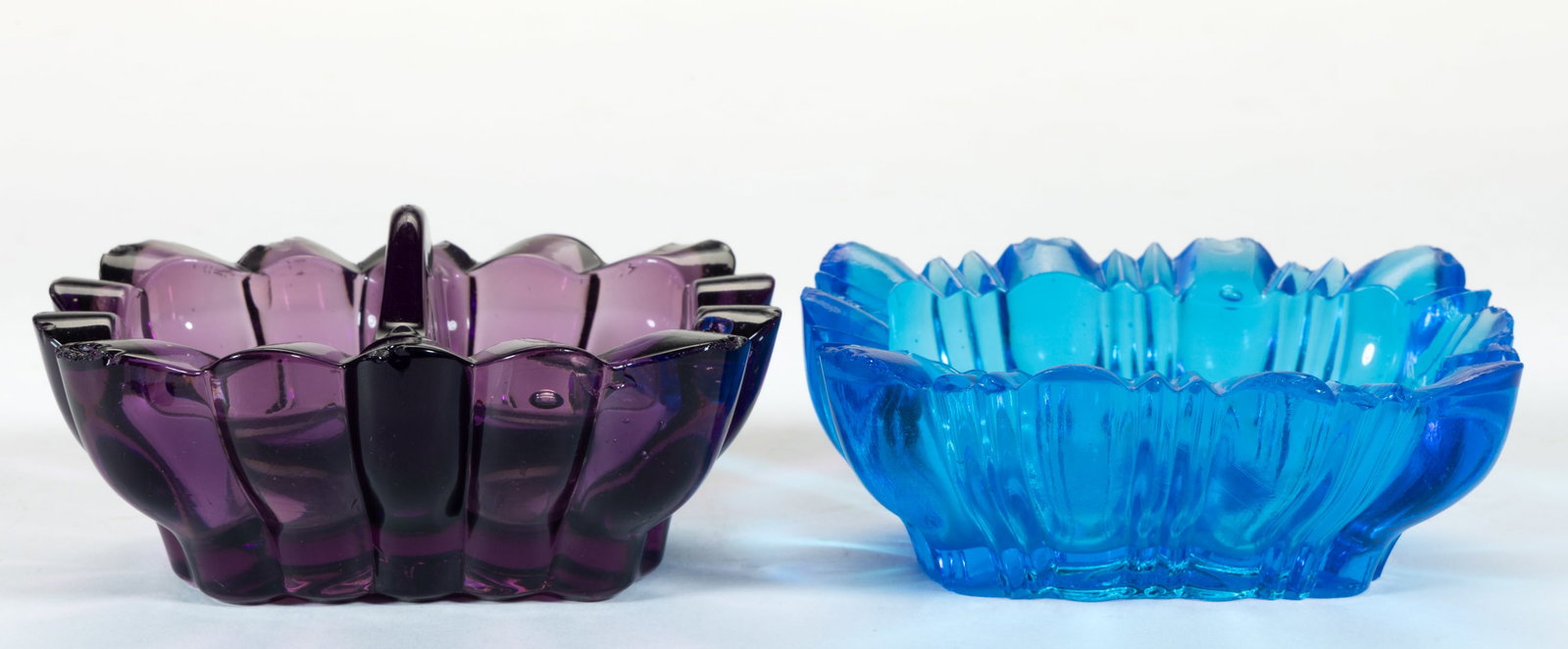 HEAVY RIB PRESSED OPEN SALTS, LOT OF TWO: HEAVY RIB PRESSED OPEN SALTS, LOT OF TWO, electric blue and amethyst, comprising an example with 14 lobes/ribs, a central divider, and a star base; and an example with 10 wide lobes separated by