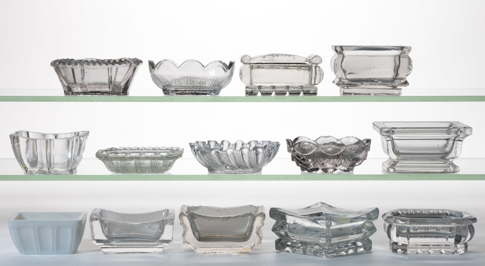 ASSORTED HEAVY PRESSED OPEN SALTS, LOT OF 14: ASSORTED HEAVY PRESSED OPEN SALTS, LOT OF 14, colorless and opaque white, many of rectangular form, and many with variations of an inverted waffle bottom. Mid 19th century. 3/4" to 1 3/4" HO