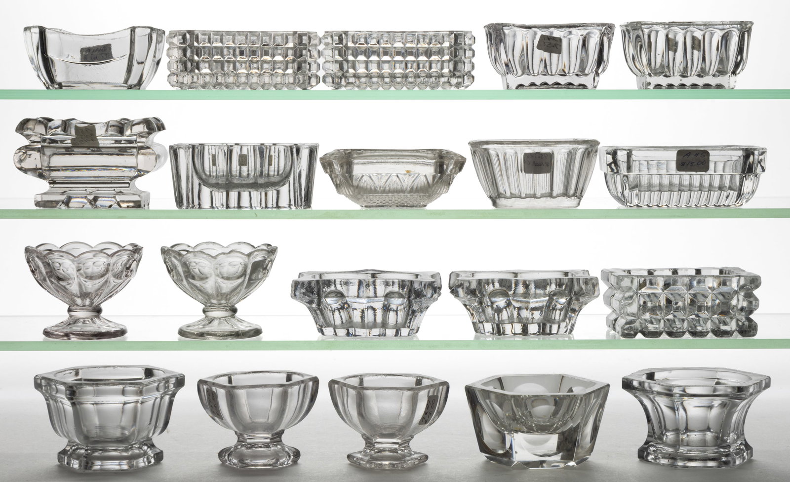 ASSORTED PRESSED GLASS OPEN SALTS, LOT OF 20: ASSORTED PRESSED GLASS OPEN SALTS, LOT OF 20, colorless, including two heavy Concave Panel and Pillar, and five hexagonal forms. Various makers. Second half 19th century. 1 1/4" to 2 1/8&quo