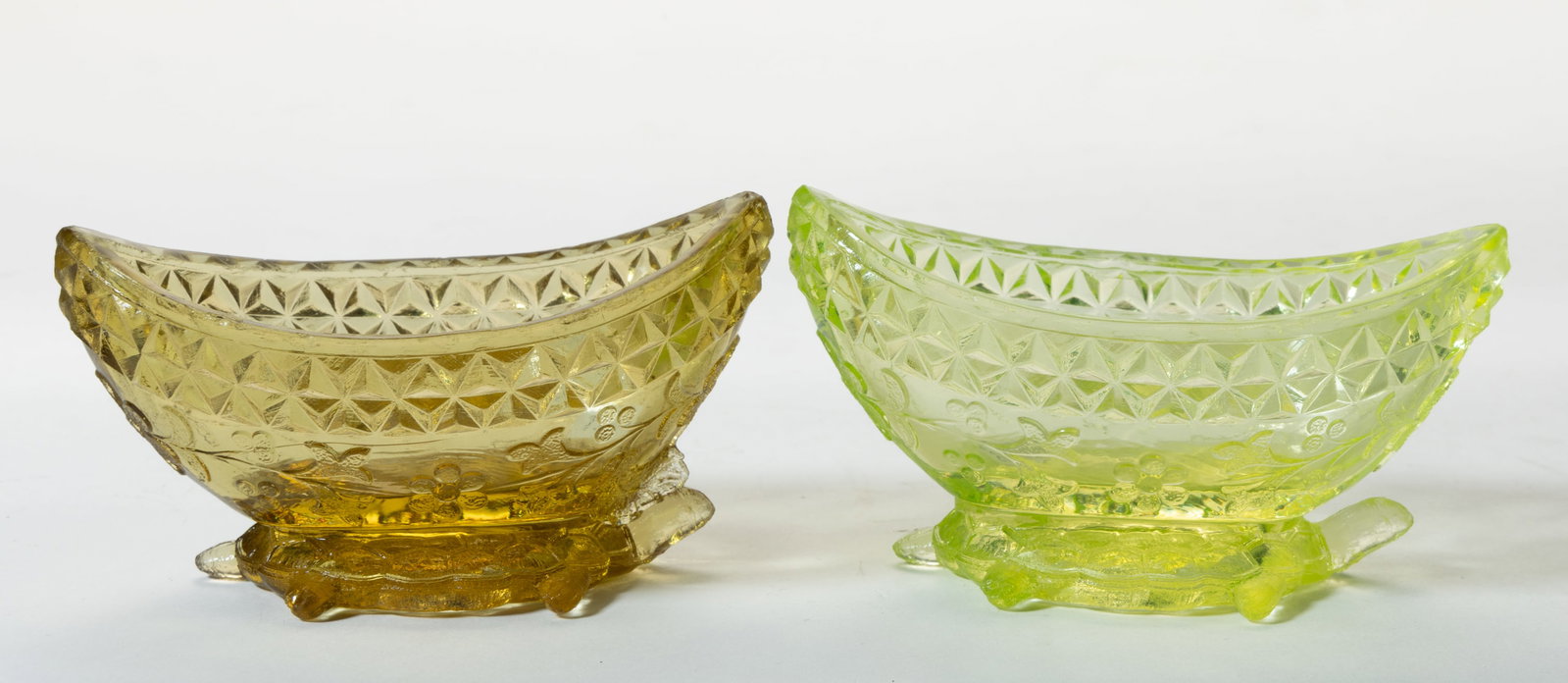 ADAMS NO. 140 / WILDFLOWER OPEN SALTS, LOT OF TWO: ADAMS NO. 140 / WILDFLOWER OPEN SALTS, LOT OF TWO, amber and Vaseline (reacts under black light), each being boat form with a figural turtle base. Adams & Co. Circa 1874. 2" H, 2" x 3 3/
