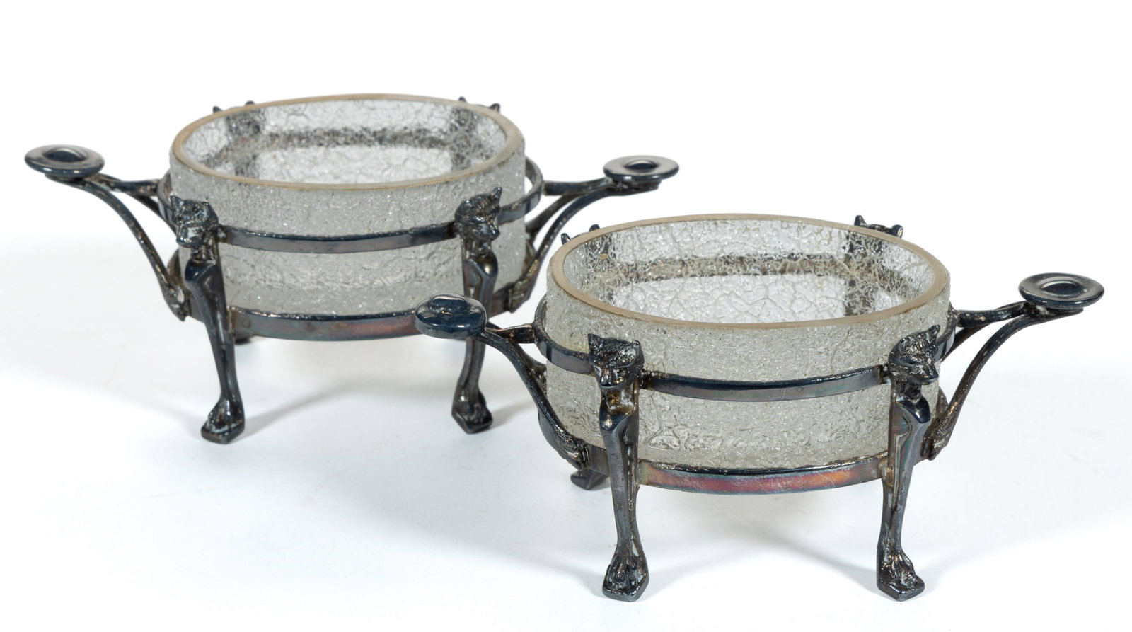 PAIR OF OVERSHOT GLASS OPEN SALTS: PAIR OF OVERSHOT GLASS OPEN SALTS, colorless, oval form with gilt decorated rim, each fitted into a quadruple-plated stand with two handles and four legs, each with figural cat head and paw, 